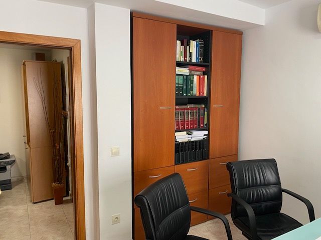 Una habitación con dos sillas y una estantería llena de libros.