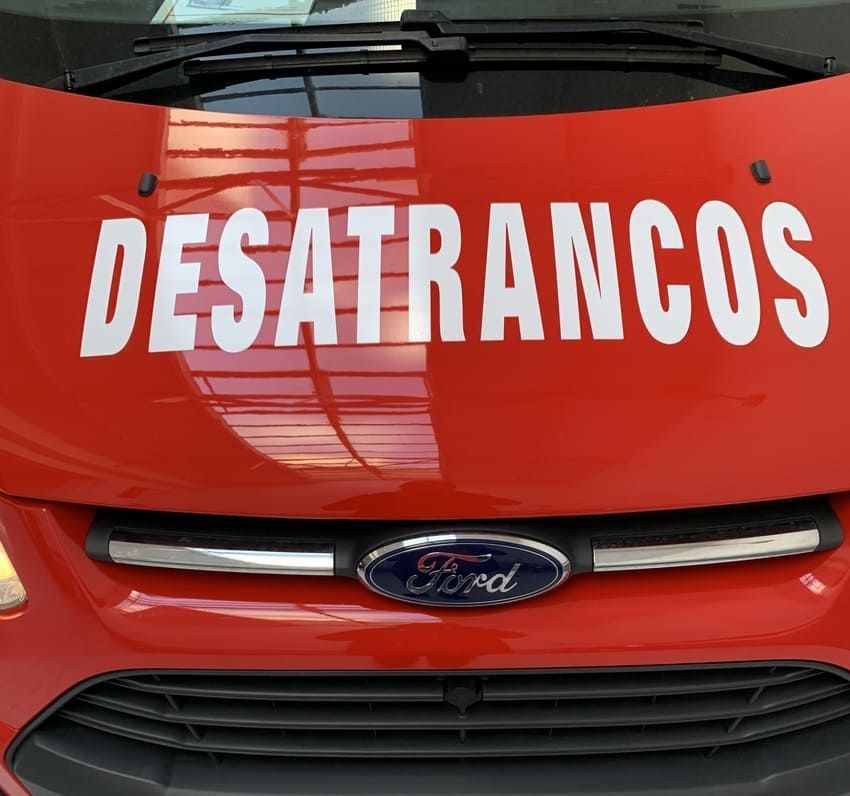 Un Ford rojo con la palabra desatrancos en el capó.