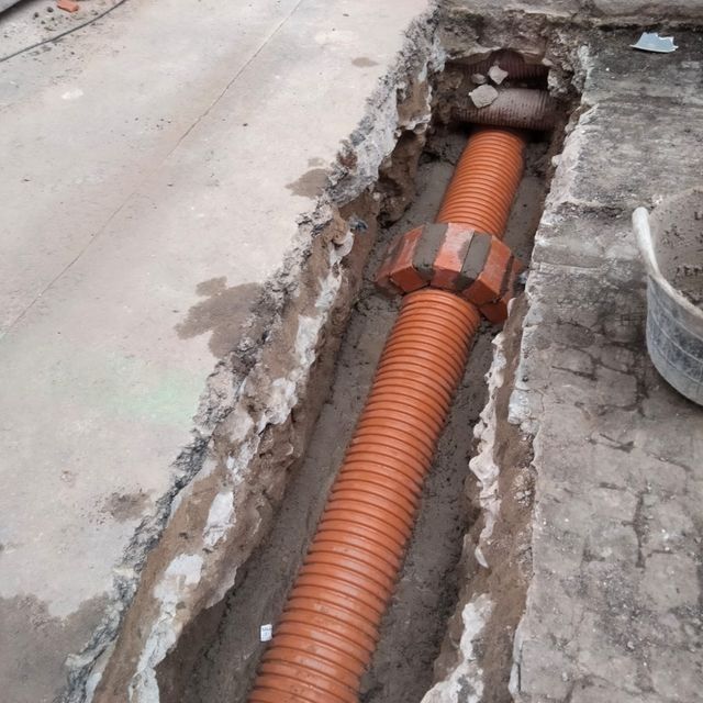 Se está instalando una tubería grande en un agujero en el suelo.