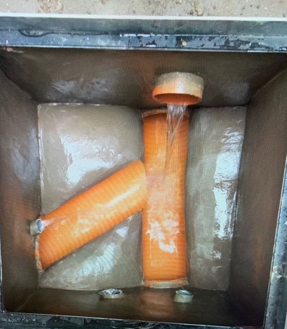 Dos tubos naranjas están conectados entre sí en una caja.