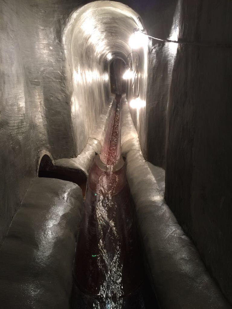 El agua sale de una tubería en un túnel.