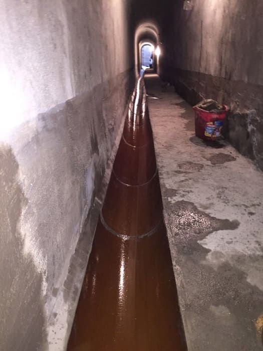 Un tubo largo de color marrón pasa por un túnel.