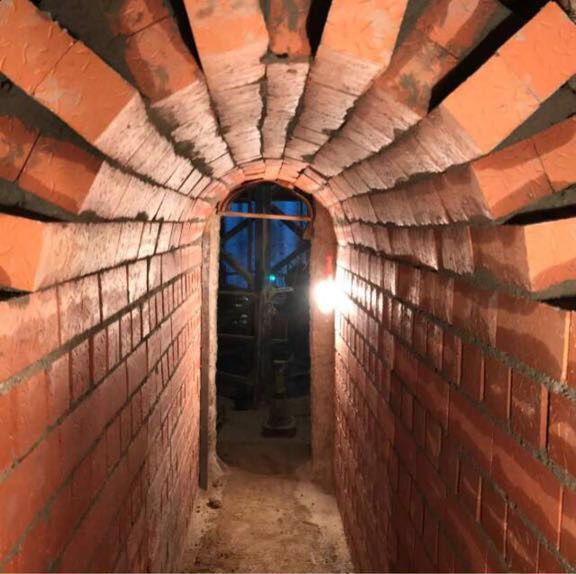 Un túnel de ladrillos con una luz al final