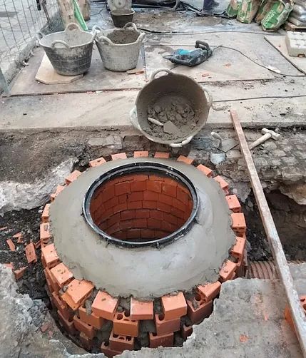 Se está construyendo un pozo de ladrillo en el suelo.