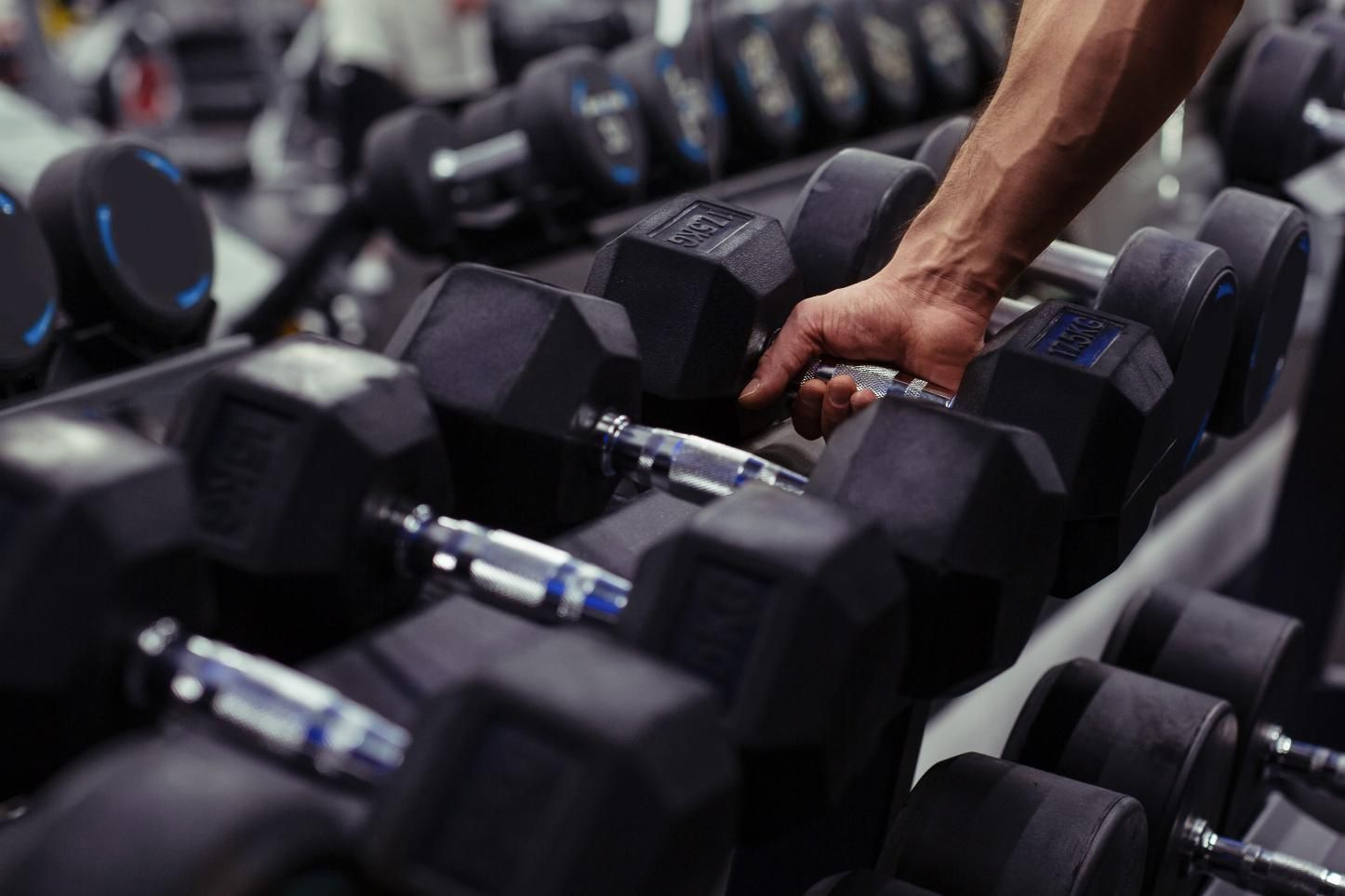 Persona en cuclillas sobre una plataforma de ejercicios redonda y transparente en un gimnasio