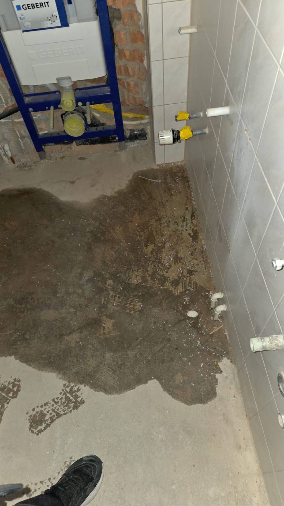 Techniker justiert in einem Maschinenraum mit einem Schraubenschlüssel industrielle Rohrleitungen und Ventile.