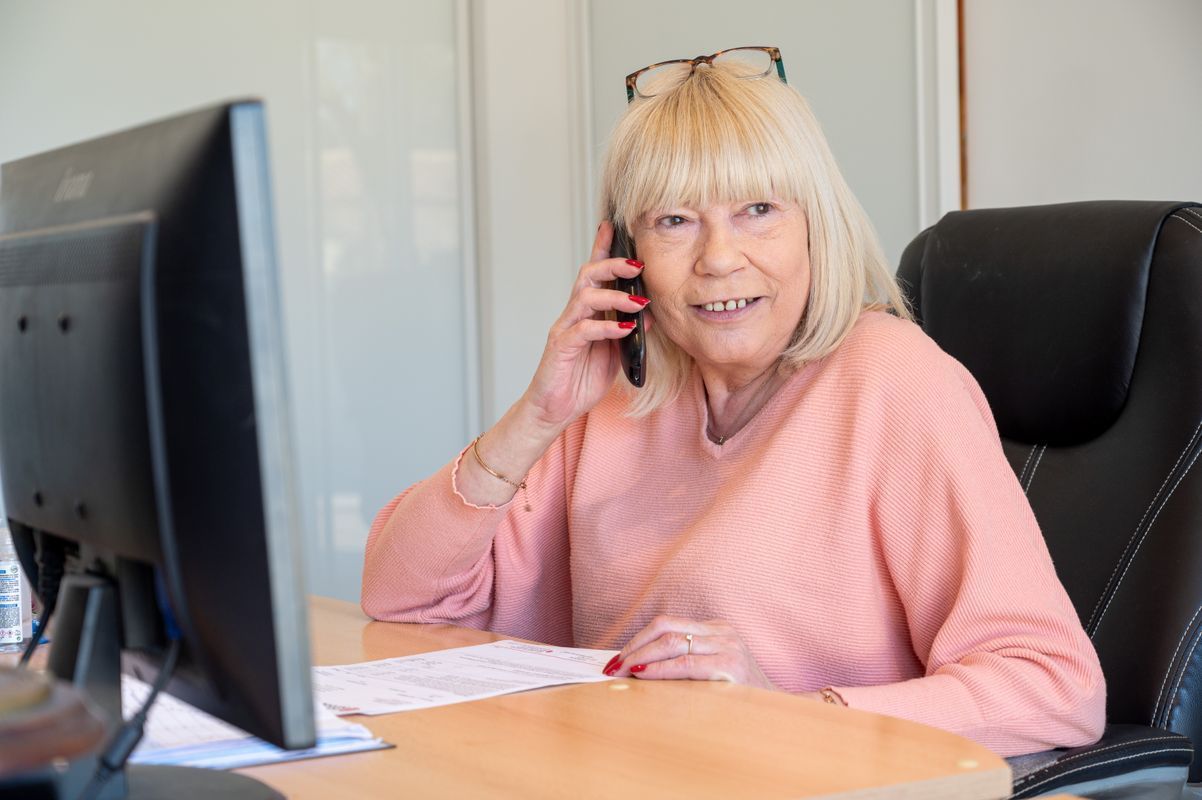 Madame Bernadac au téléphone à son bureau, à côté d’un écran d’ordinateur