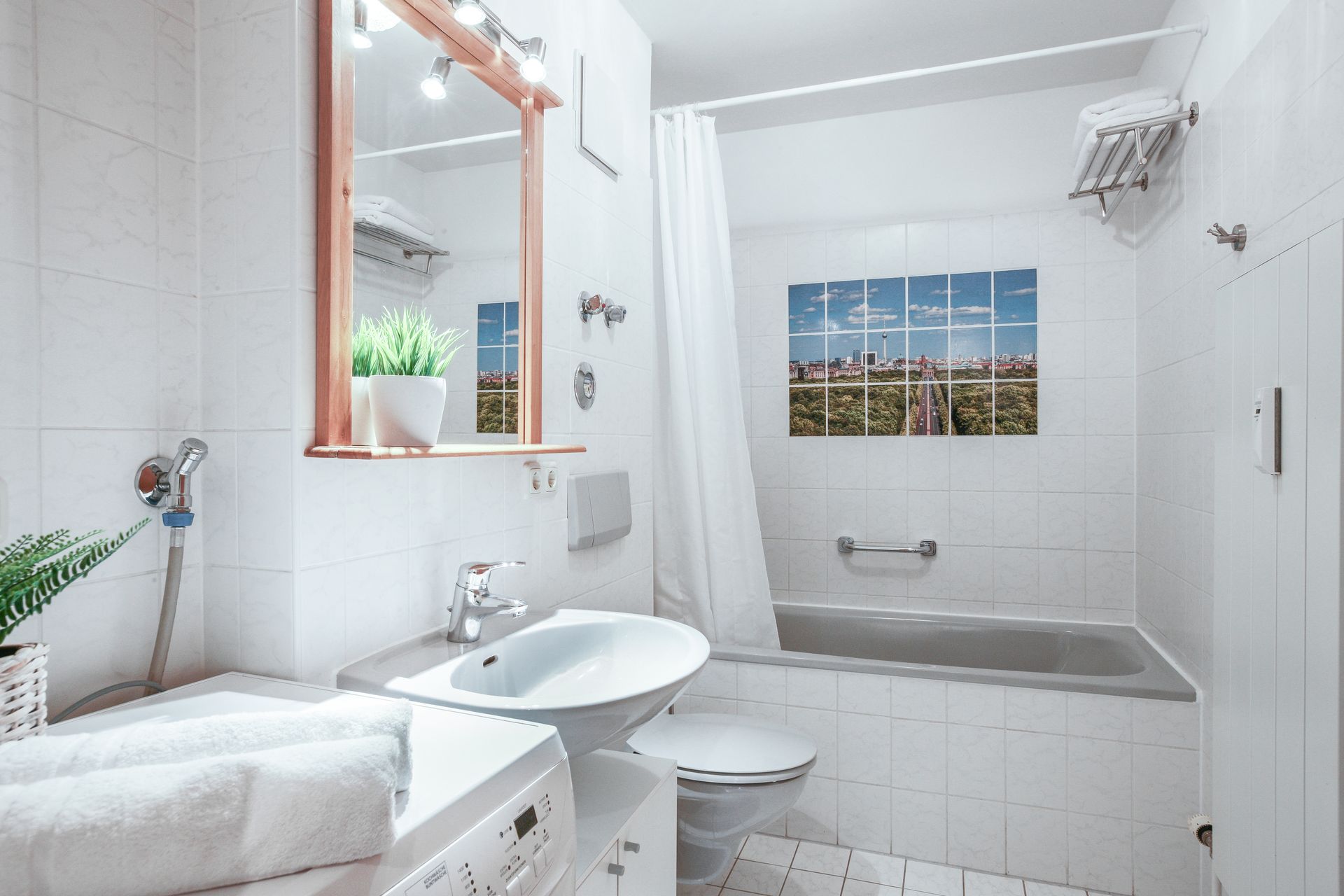 A bathroom with a sink , toilet , bathtub and mirror