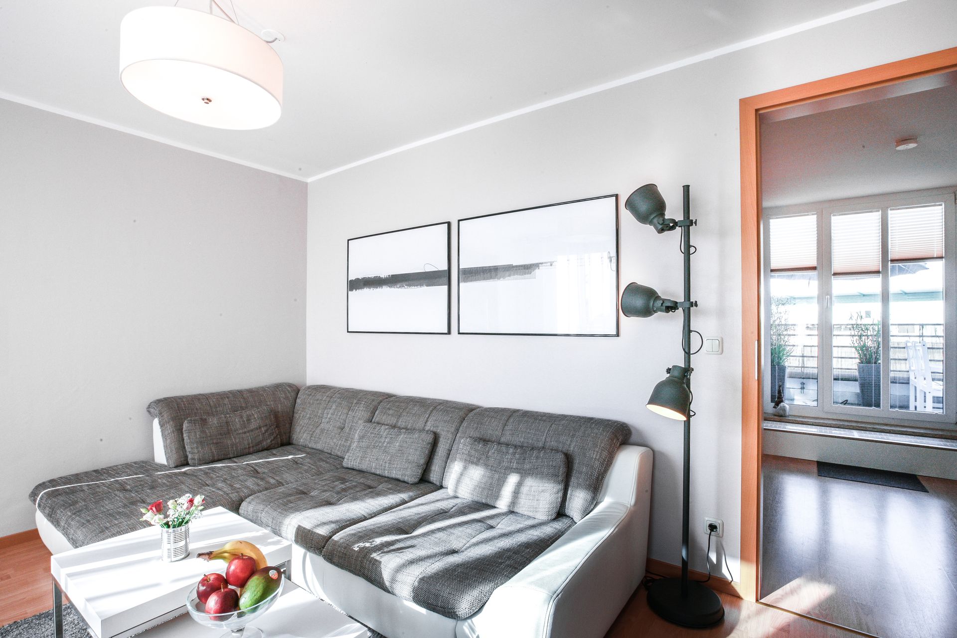 A living room with a couch , coffee table , and lamp.