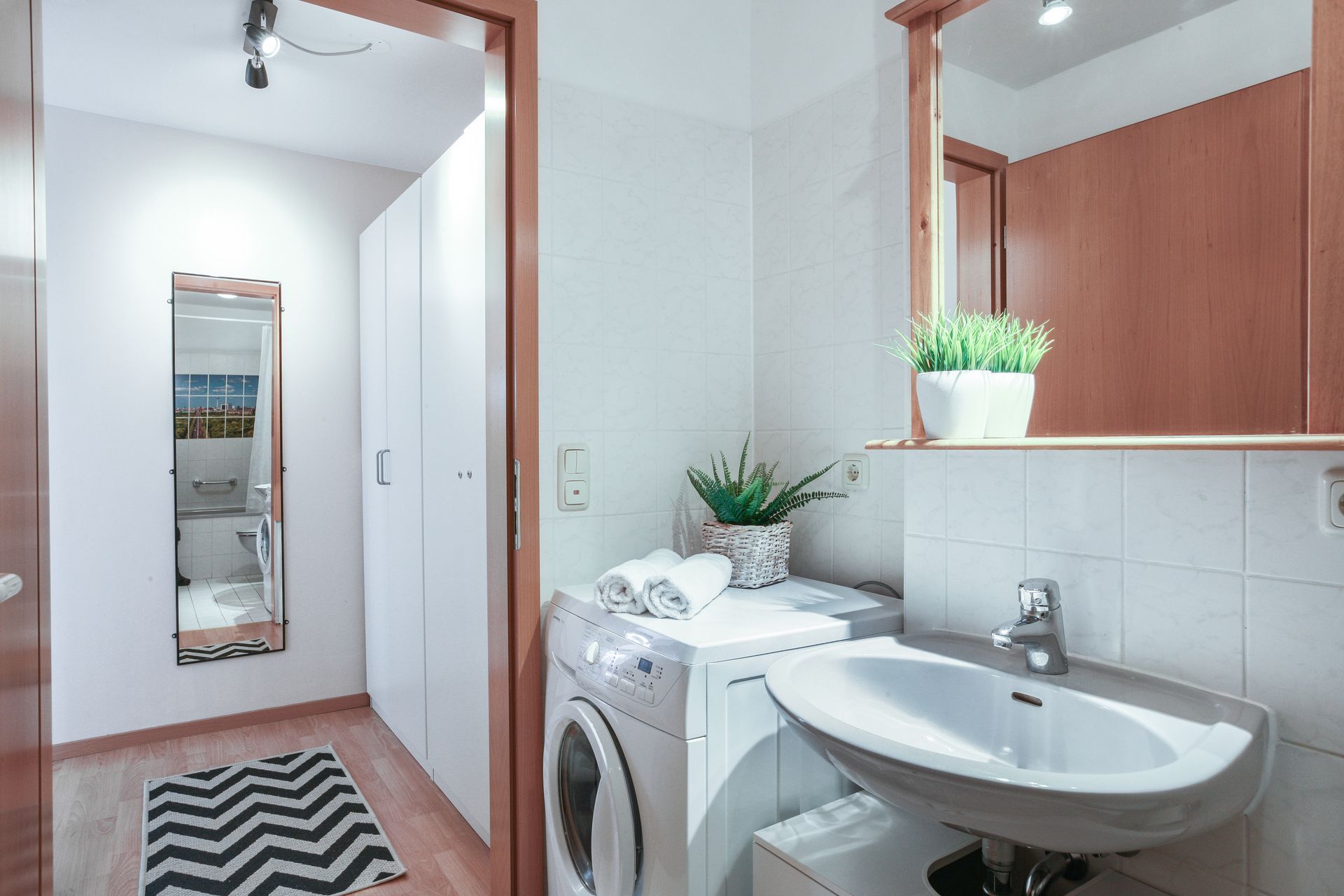 A bathroom with a sink , washer and dryer.