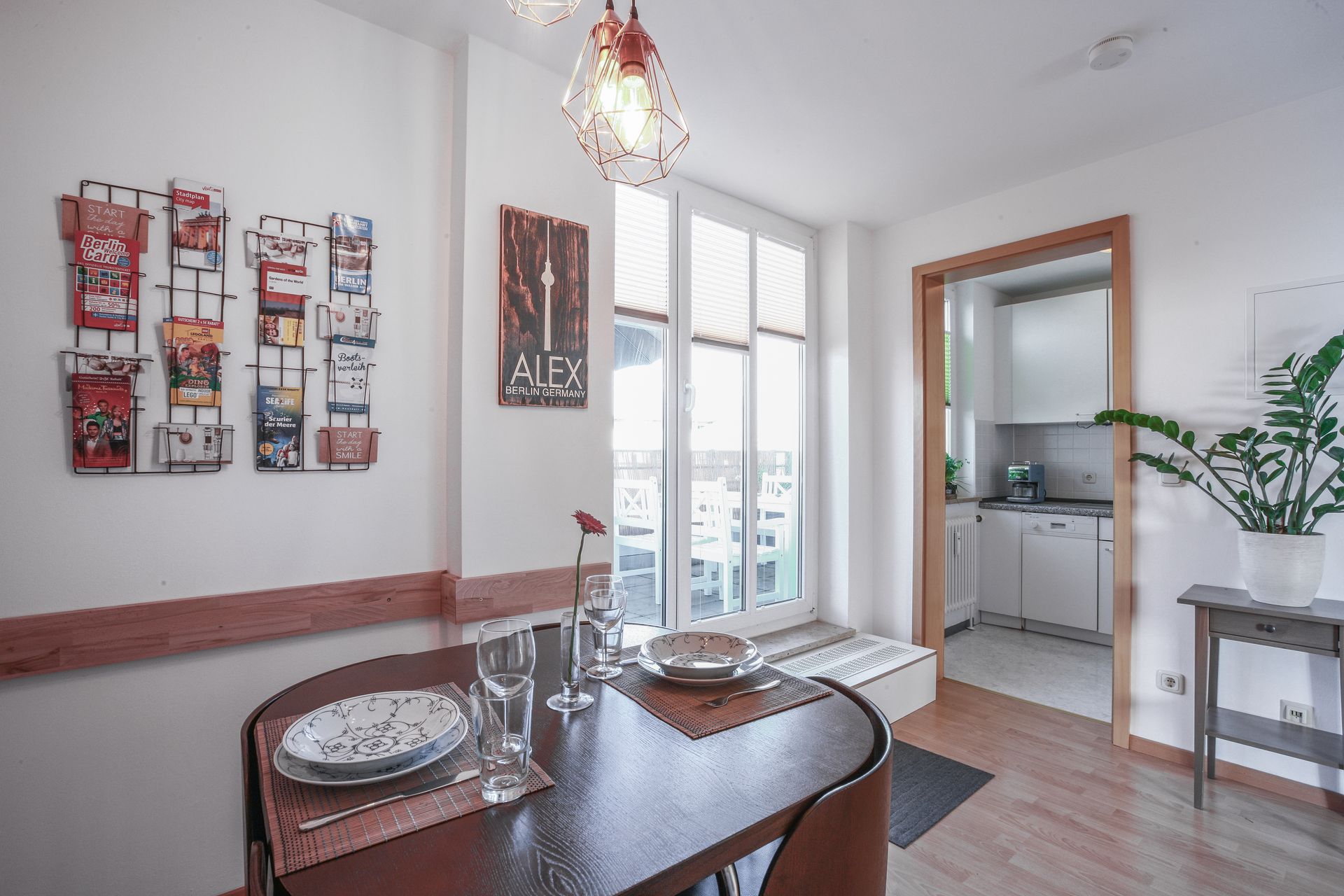 A dining room with a table and chairs and plates on it.