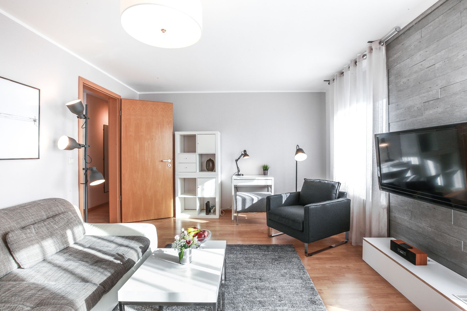 A living room with a couch , chair , table and television.