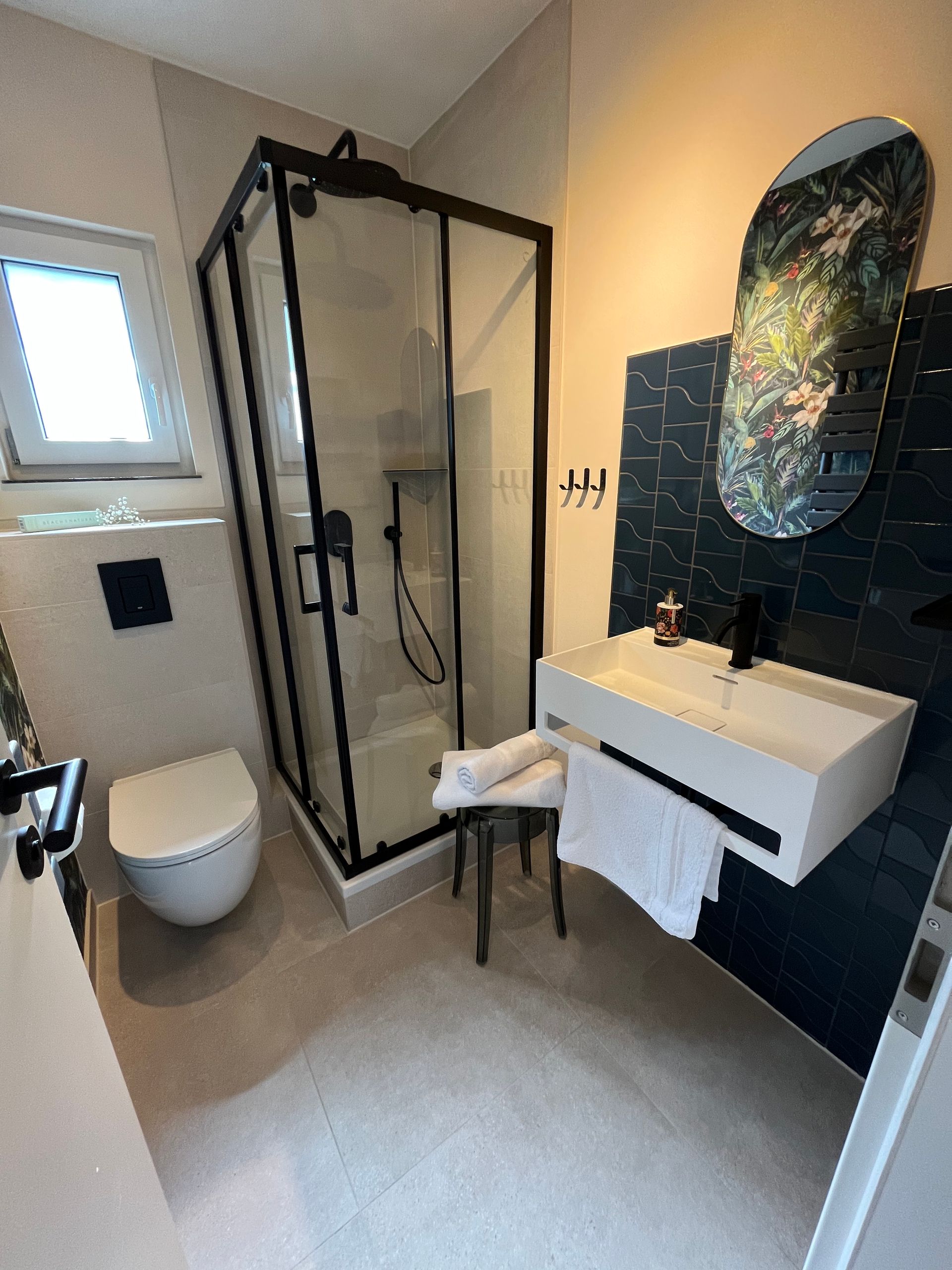 A bathroom with a toilet , sink , shower and mirror.
