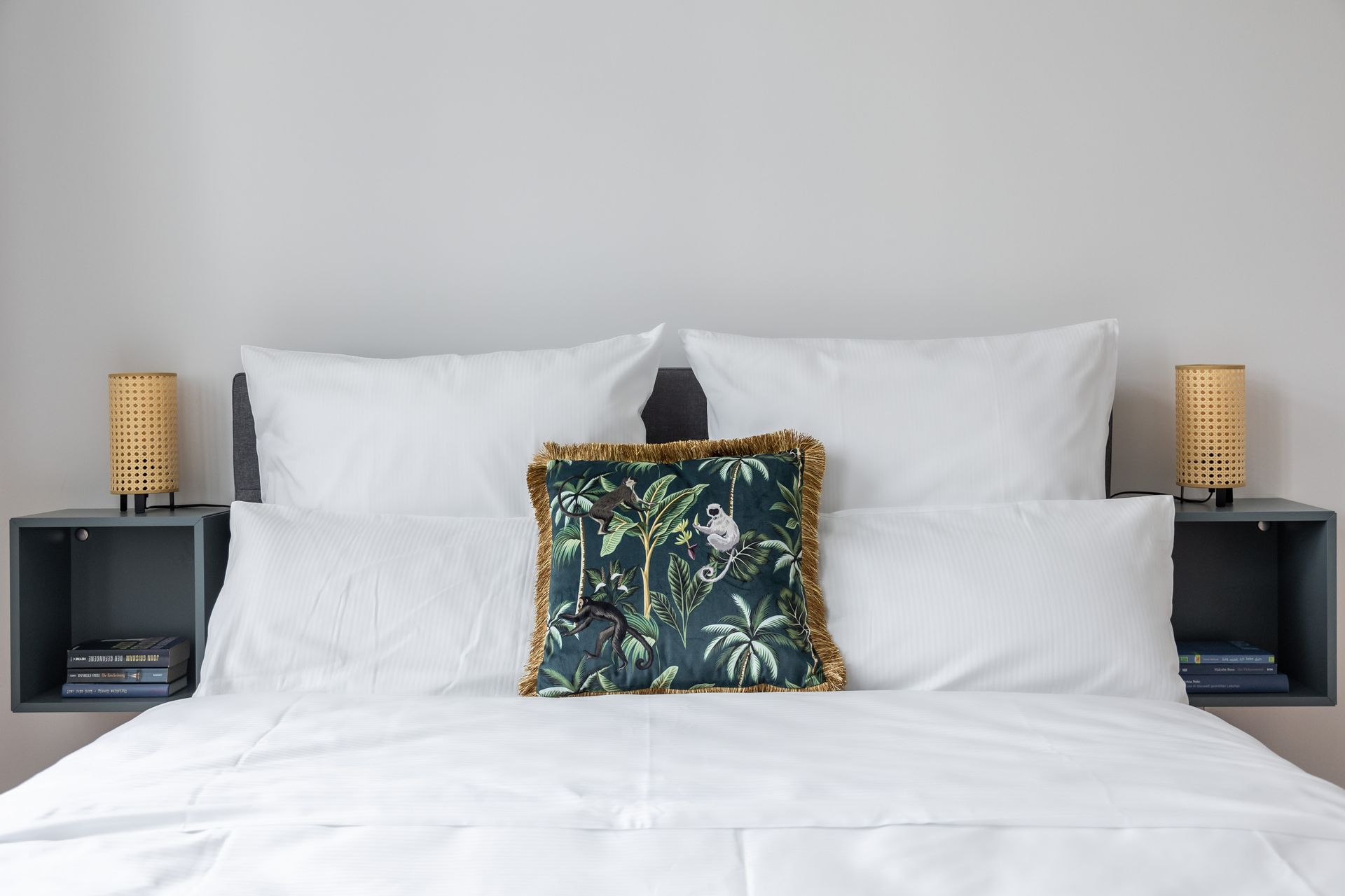 A bed with white sheets and a blue pillow on it.