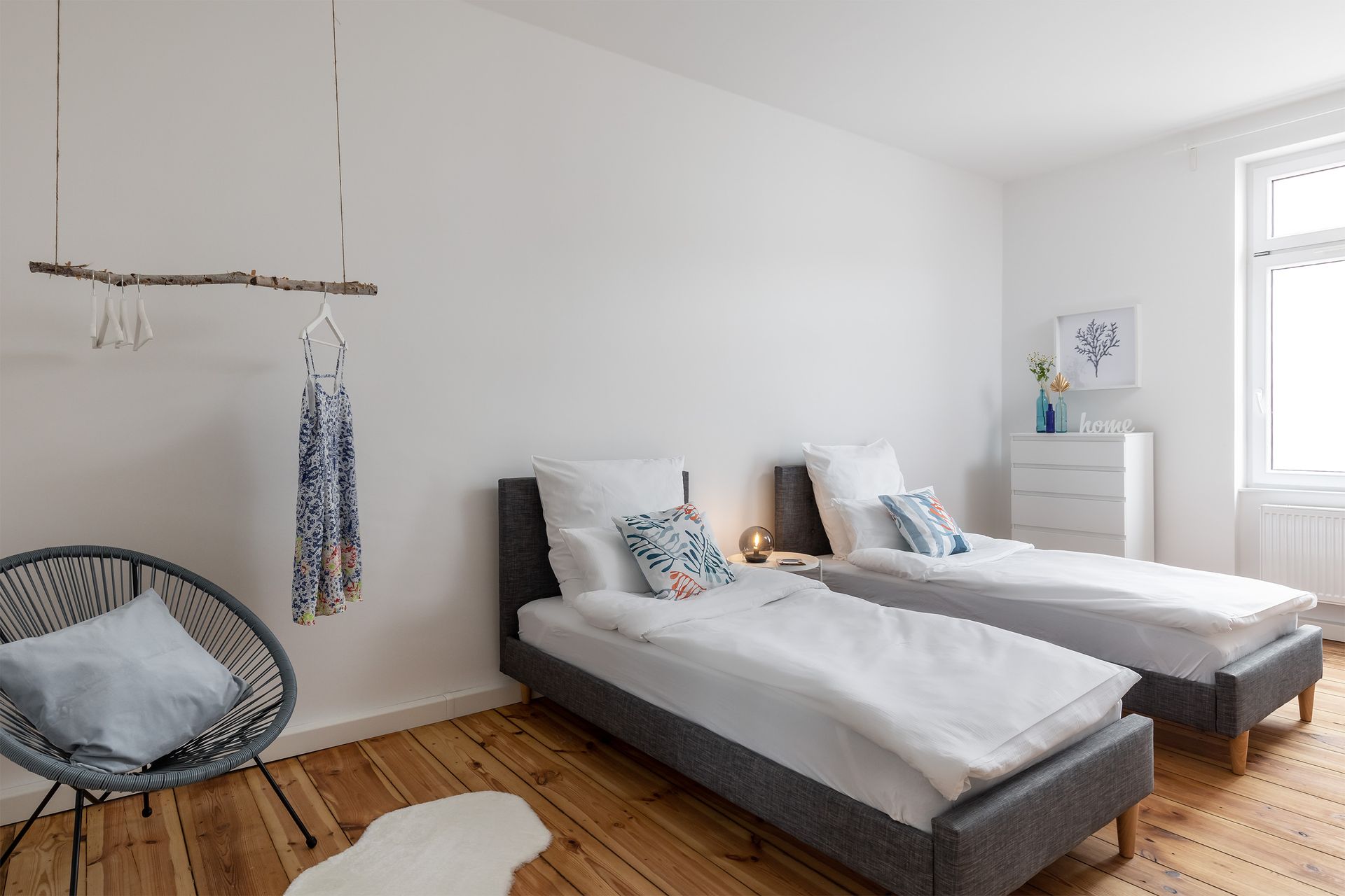 A bedroom with two twin beds and a chair.