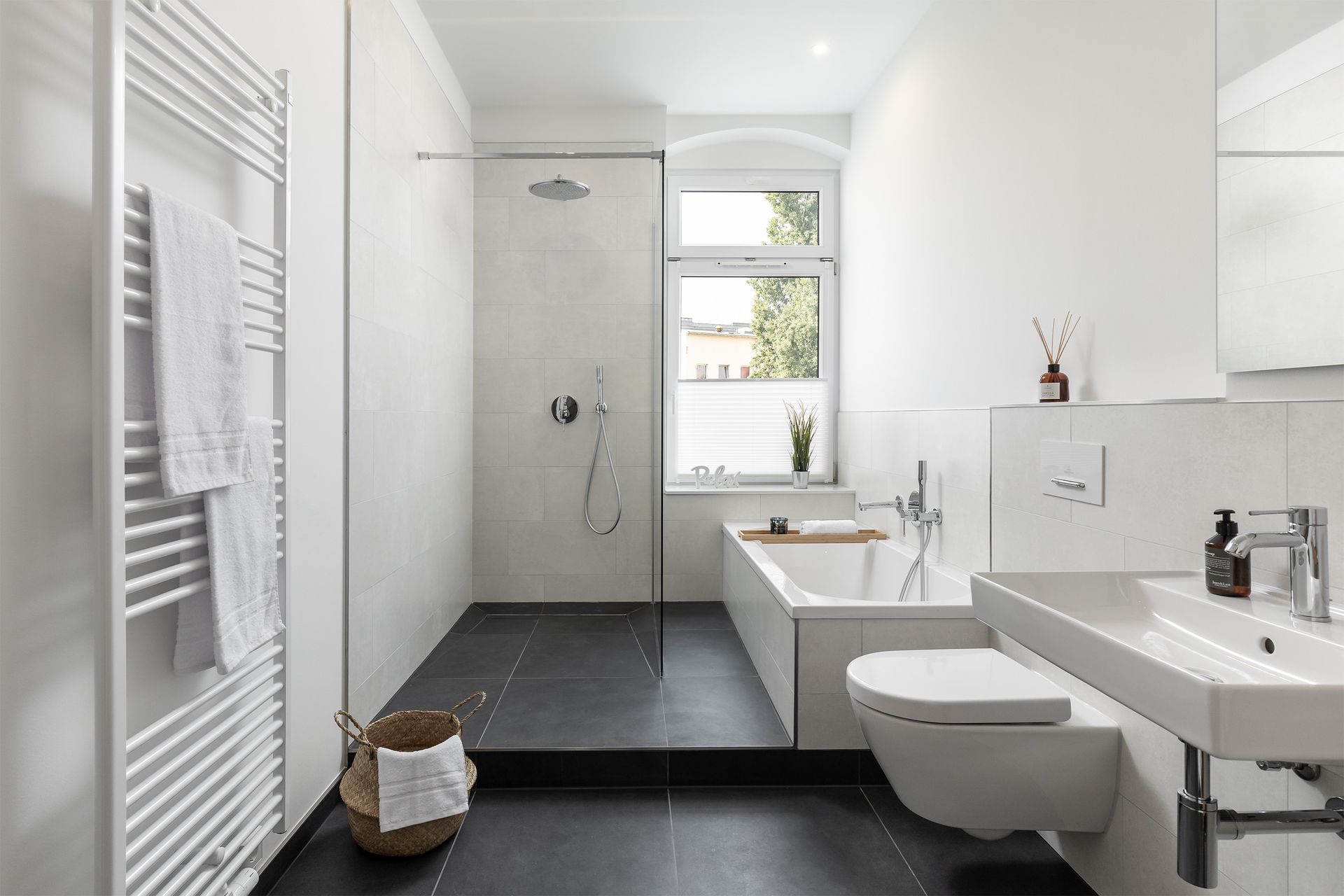 A bathroom with a bathtub , toilet , sink and shower.