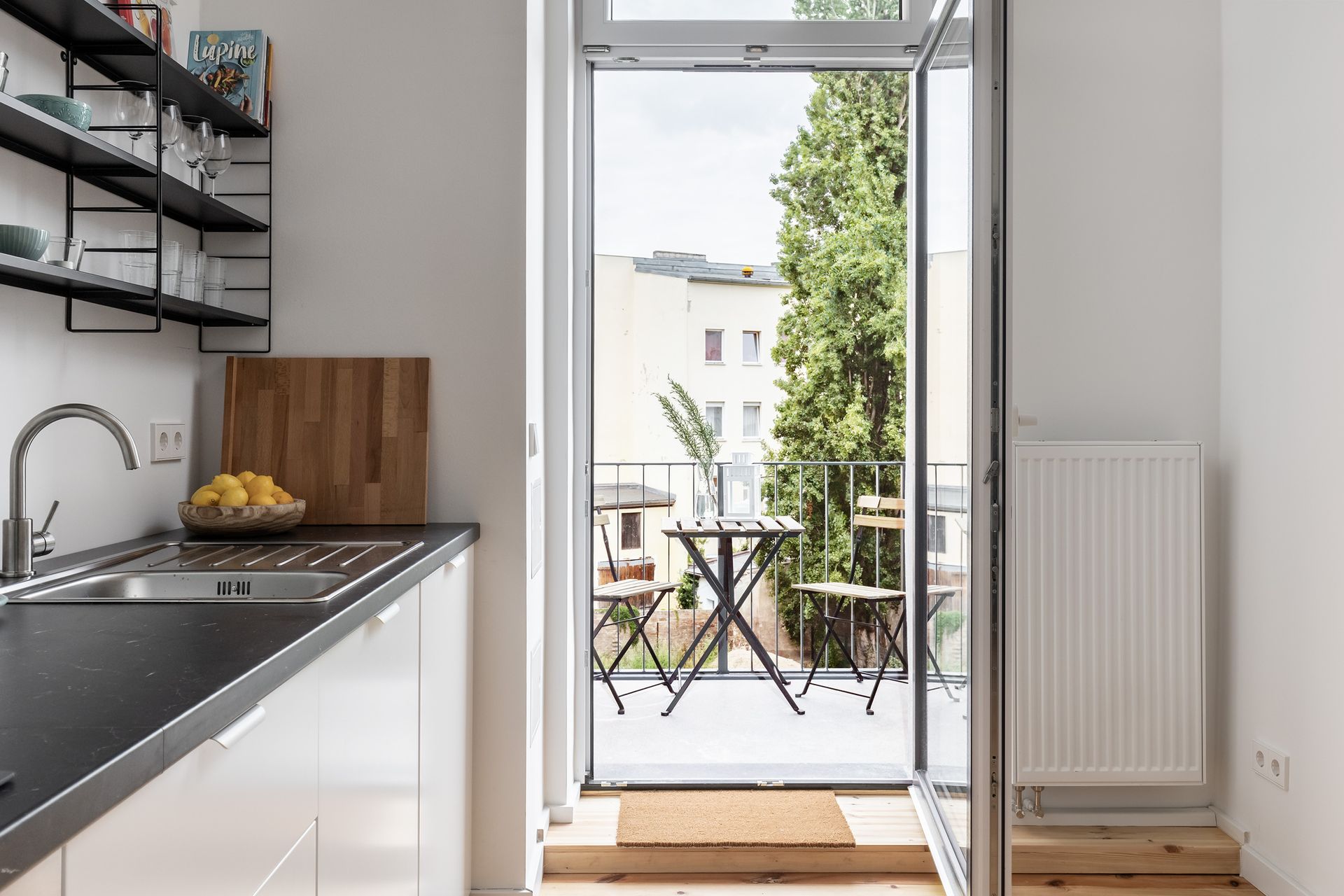 A kitchen with a sliding glass door leading to a balcony.