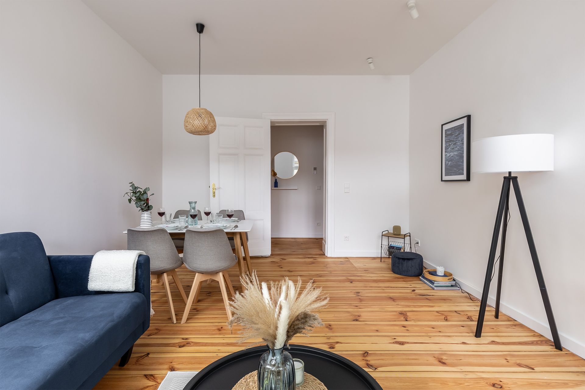 A living room with a couch , table , chairs and a lamp.