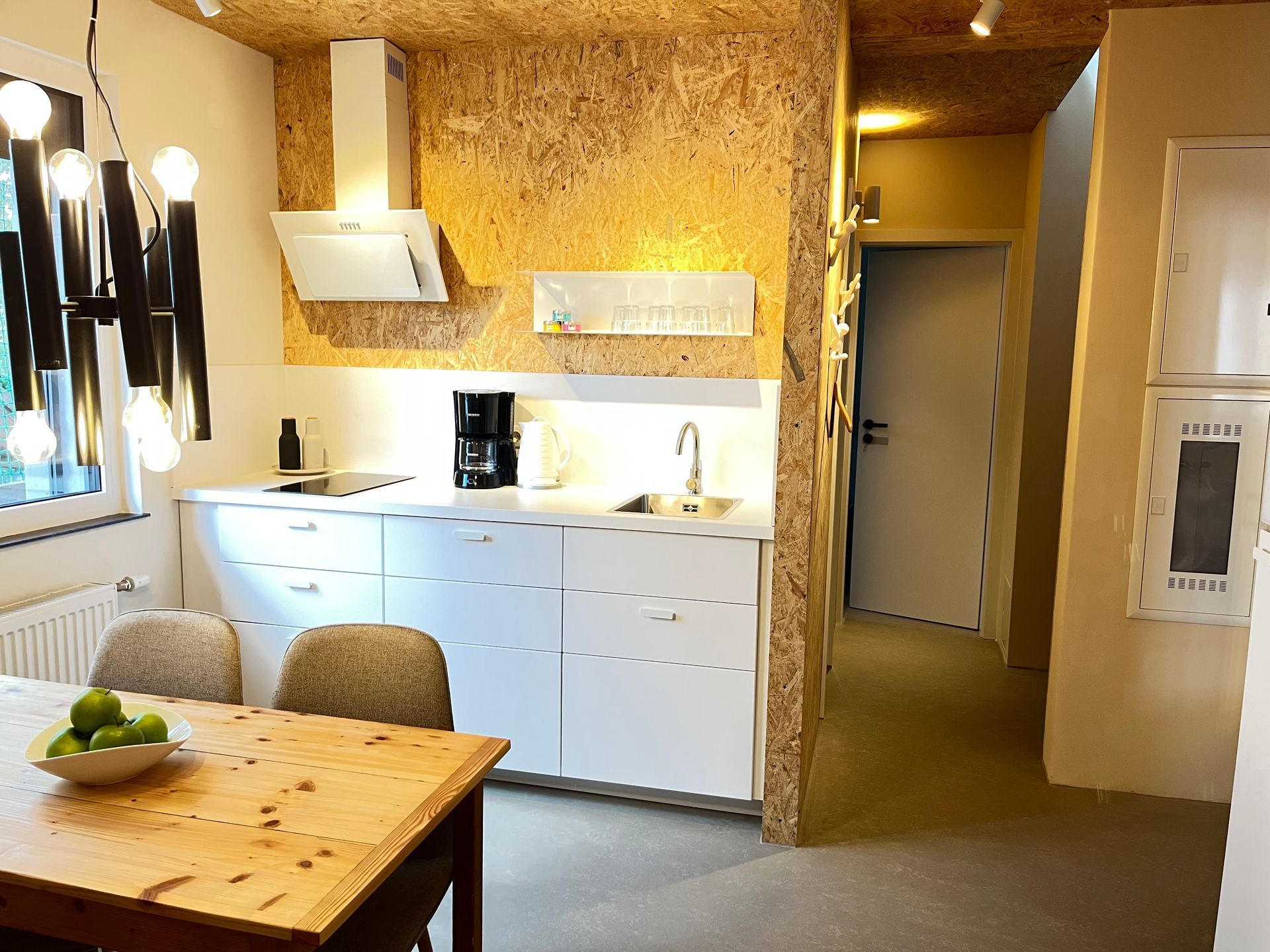 A kitchen with white cabinets and a wooden table