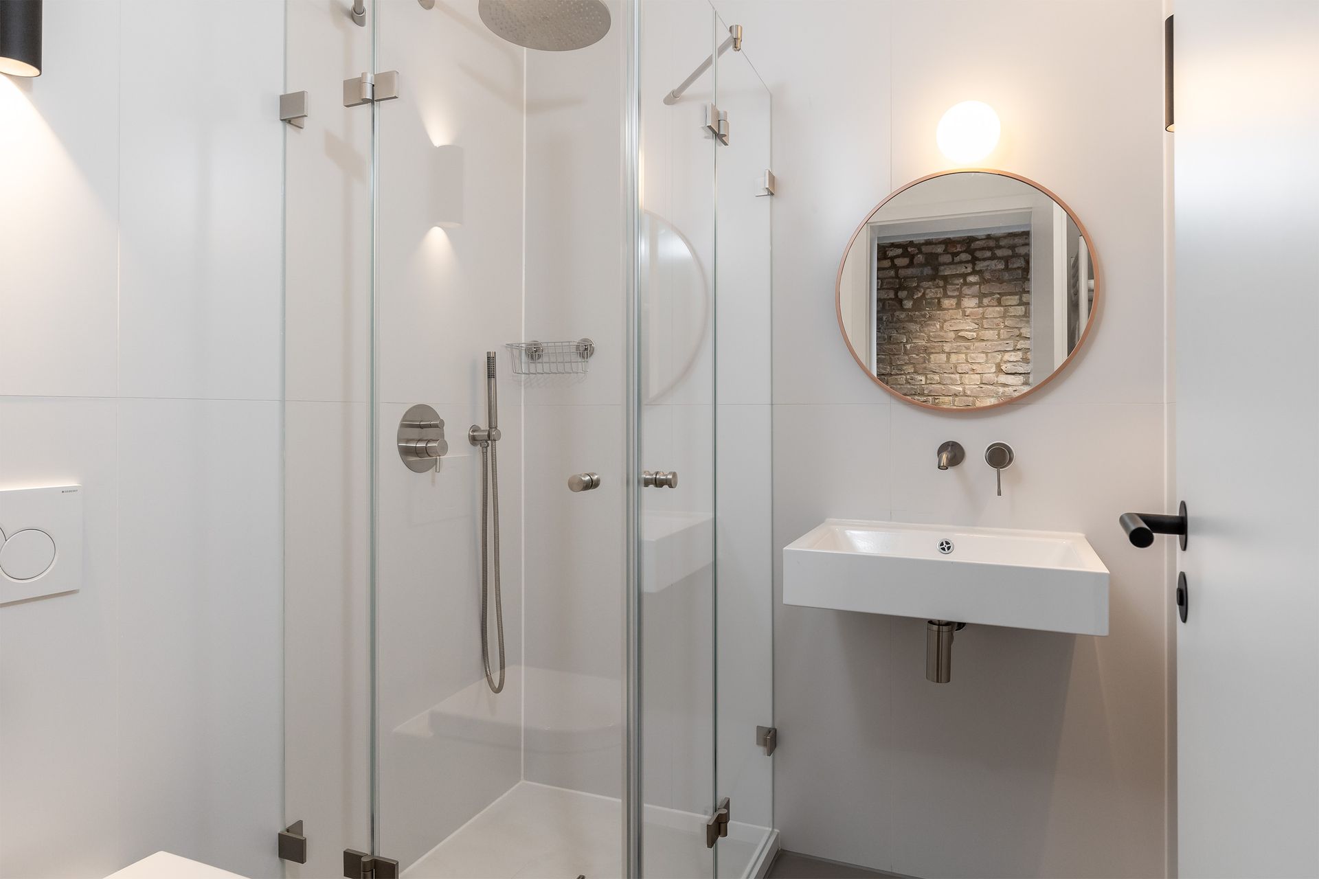 A bathroom with a shower , sink and mirror.
