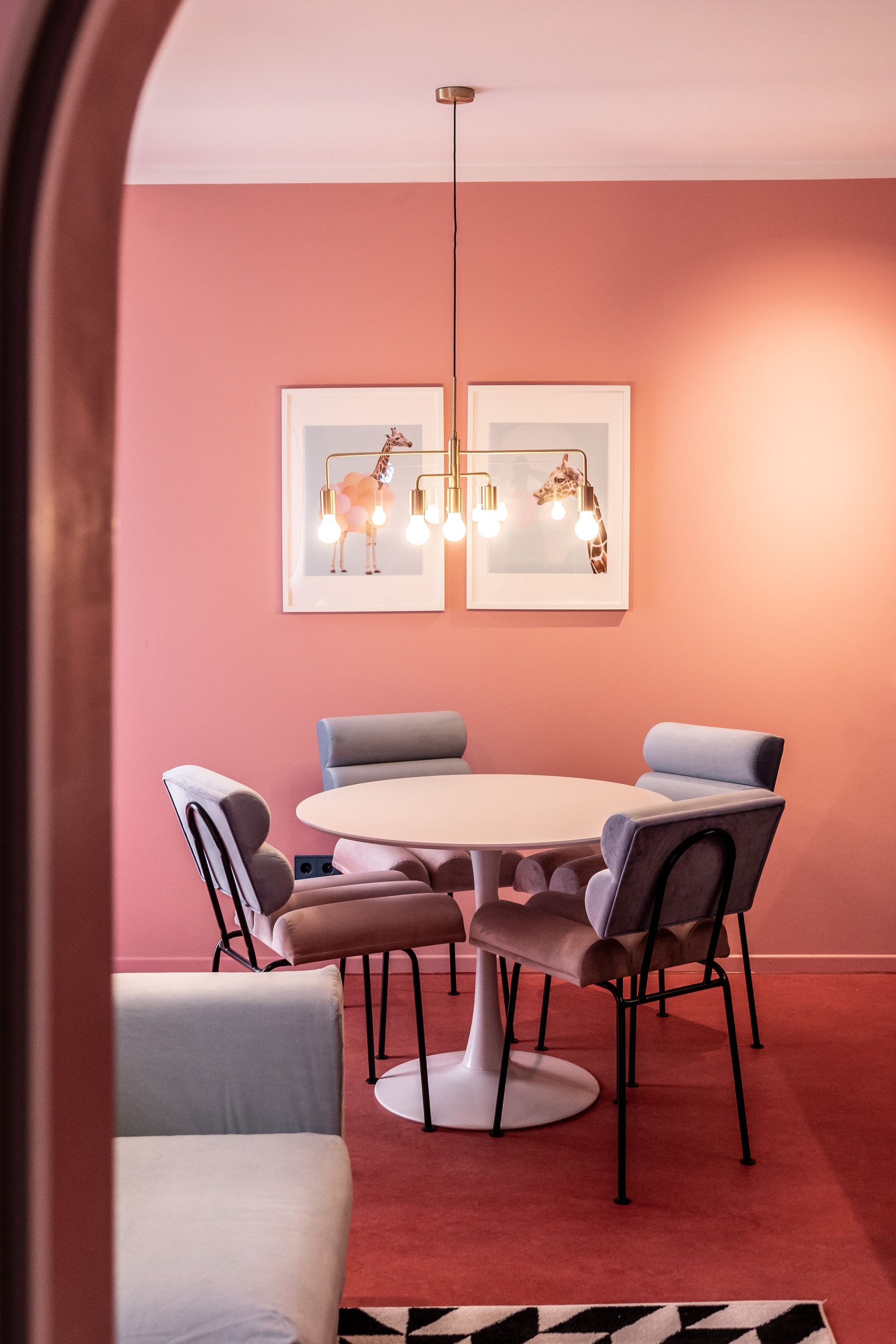 A room with pink walls and a round table and chairs