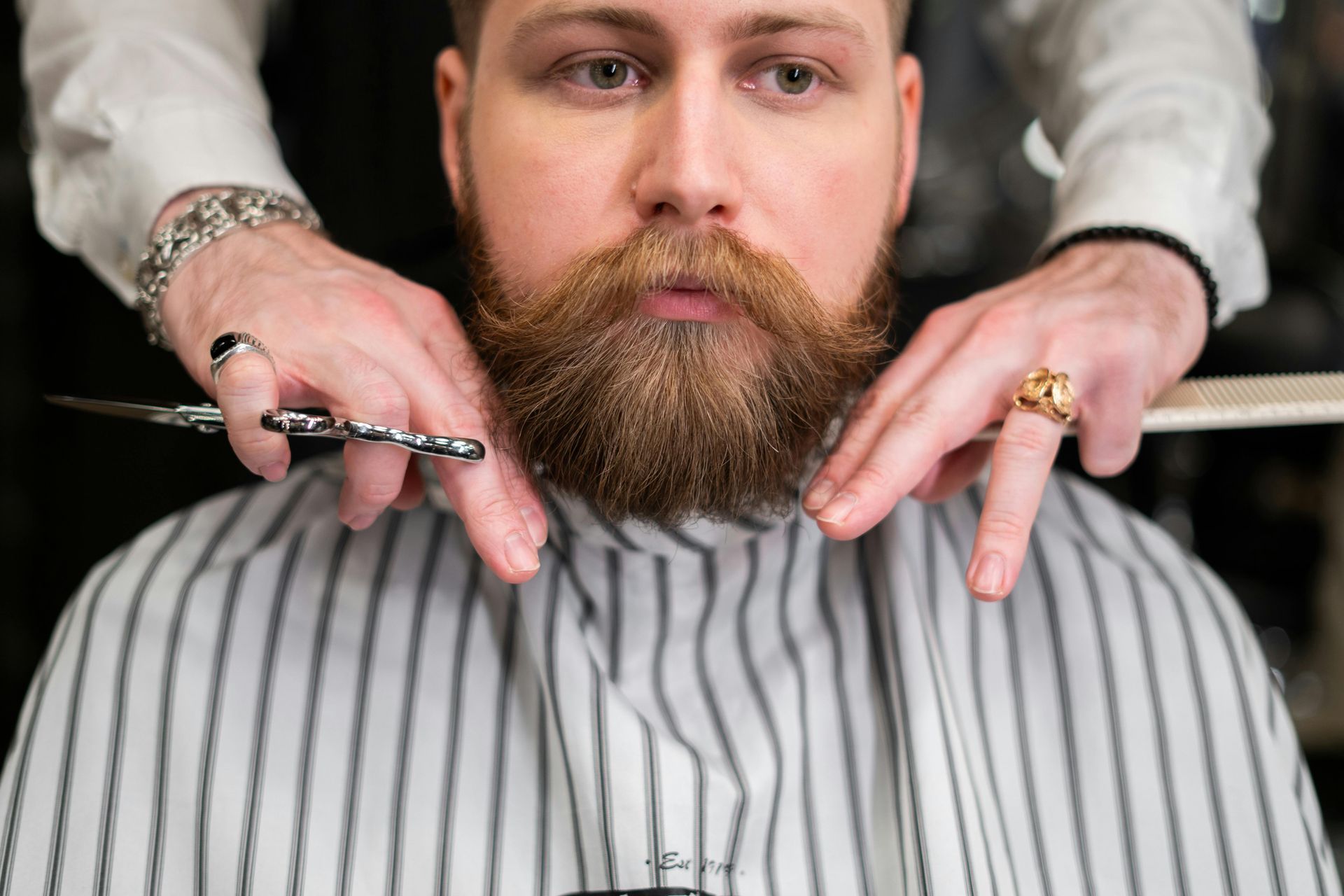 Un hombre se está cortando la barba con un barbero.