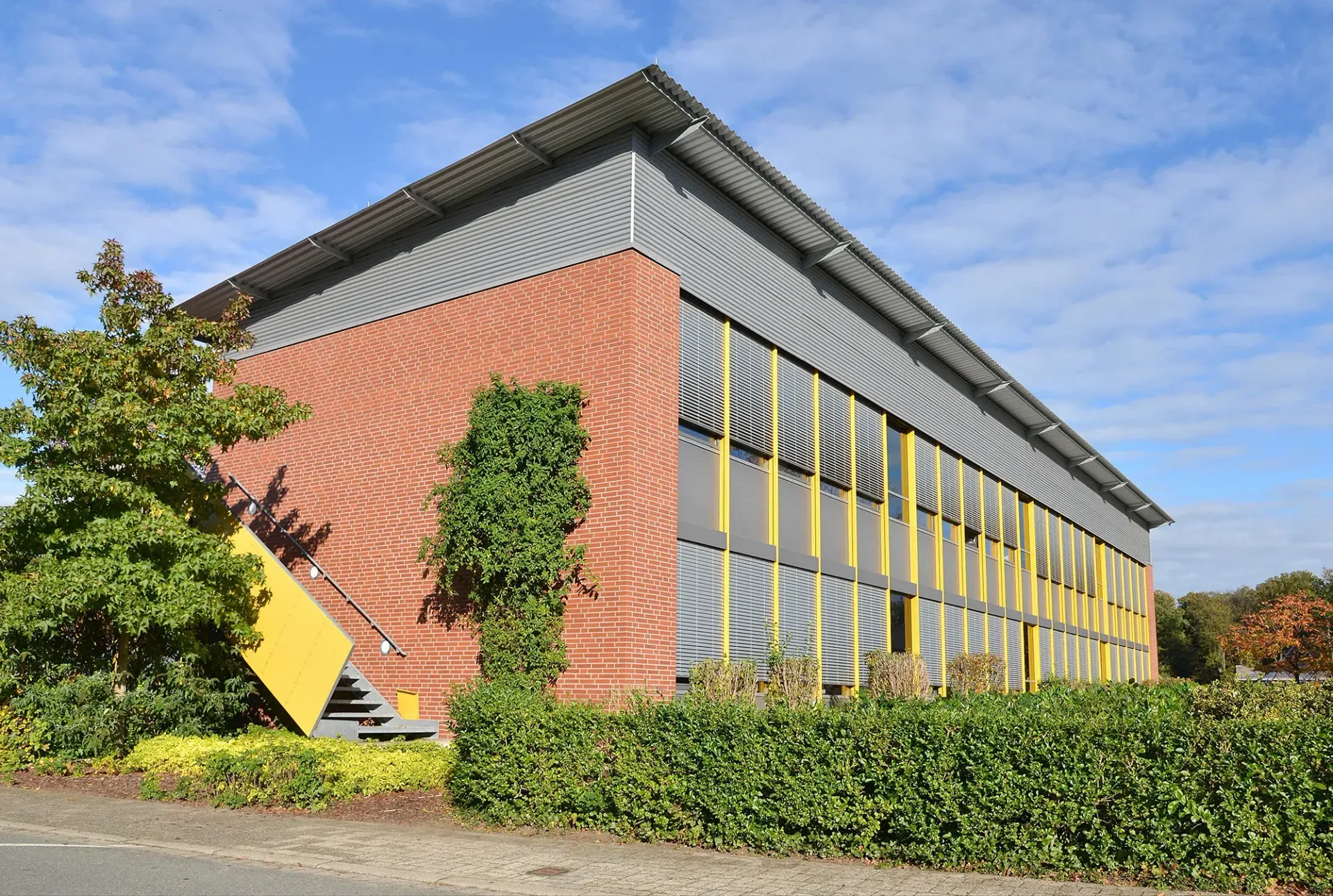 Ein großes Backsteingebäude mit einem gelben Schild an der Seite.