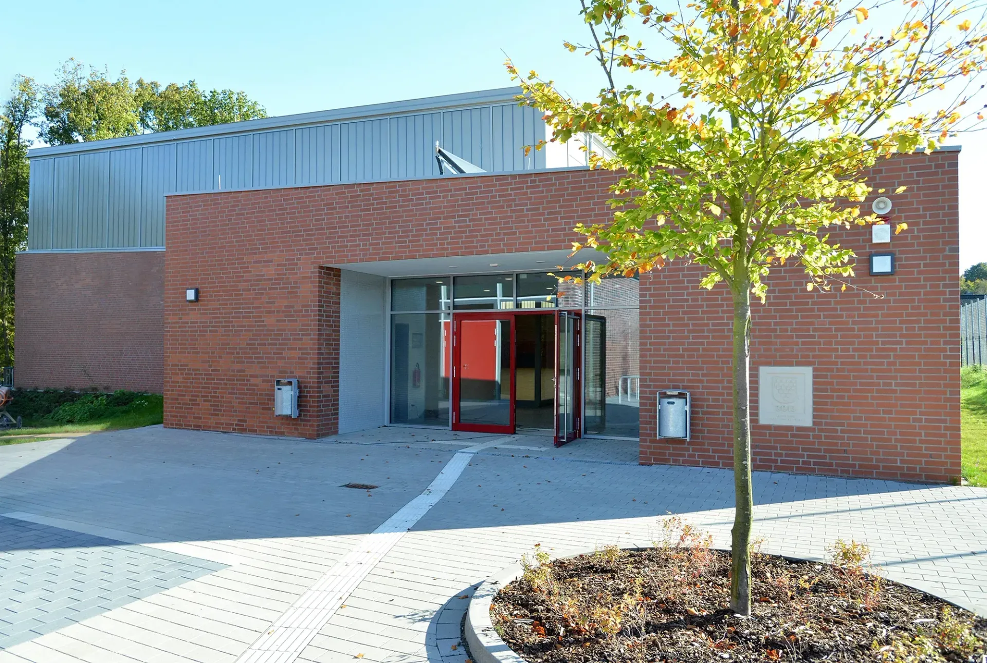 Ein Backsteingebäude mit einem Baum davor