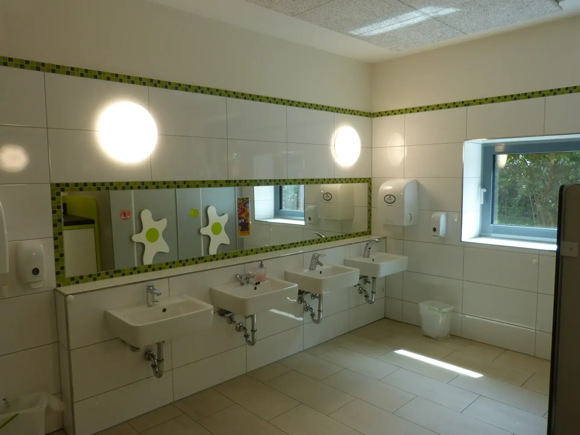 Ein Badezimmer mit vielen Waschbecken und Spiegeln