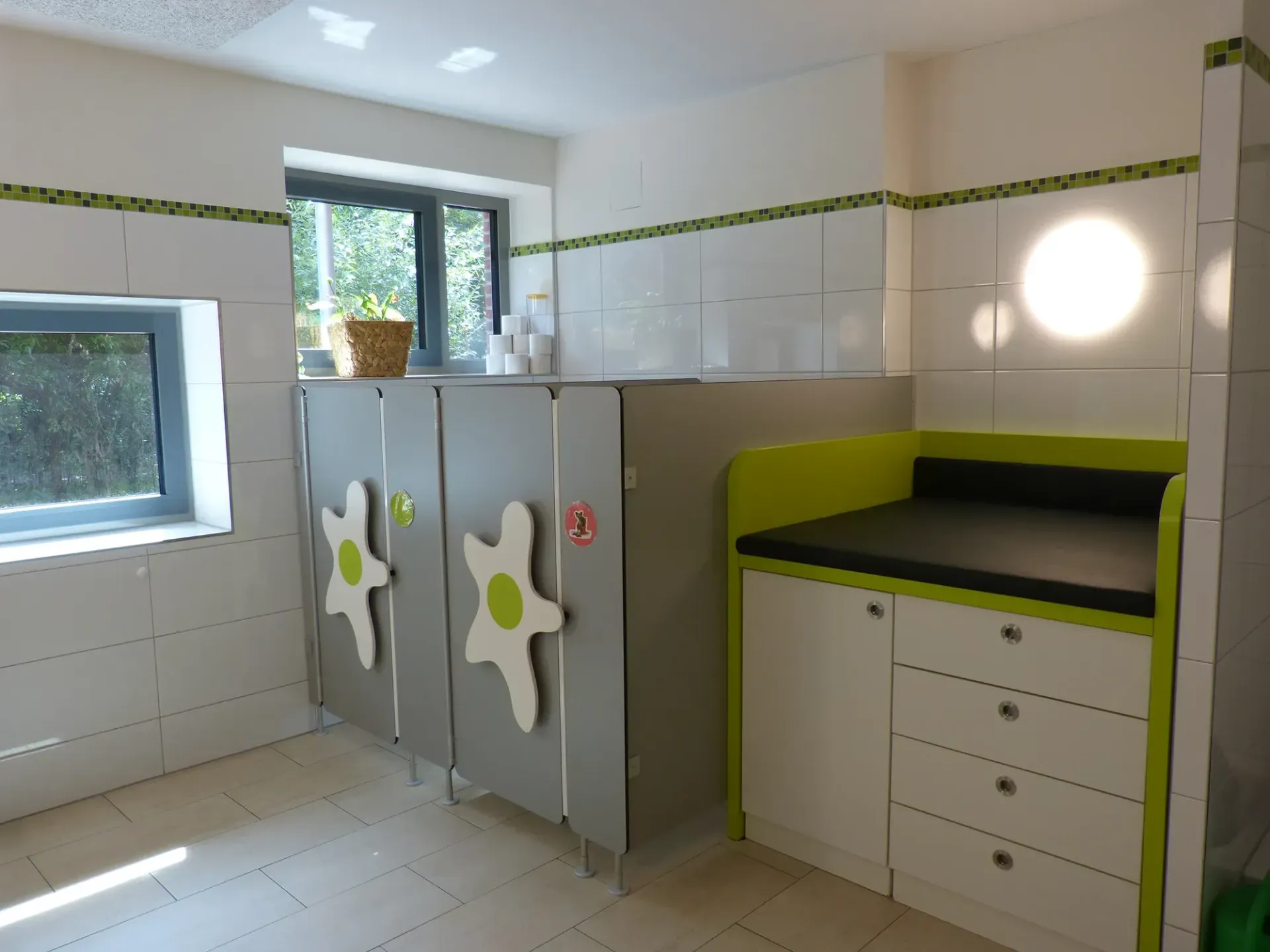Ein Badezimmer mit Wickeltisch und Fenster