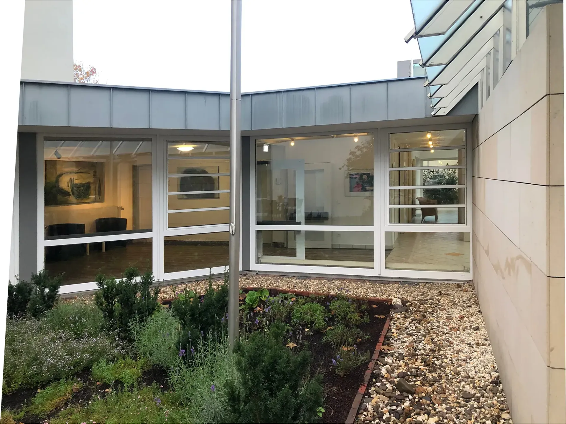 Ein Gebäude mit vielen Fenstern und einem Garten davor.