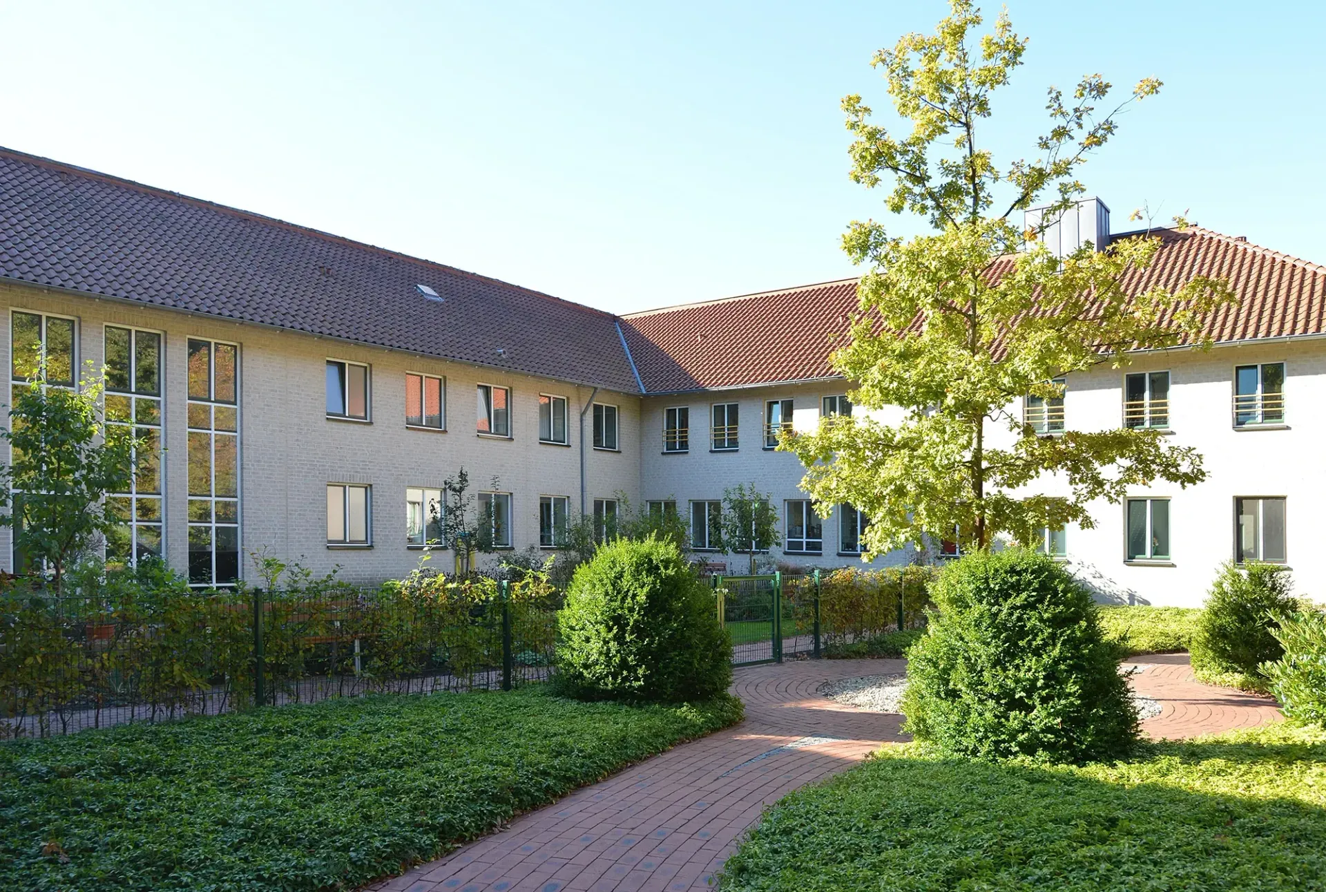 Ein großes Gebäude, zu dem ein gemauerter Gehweg führt