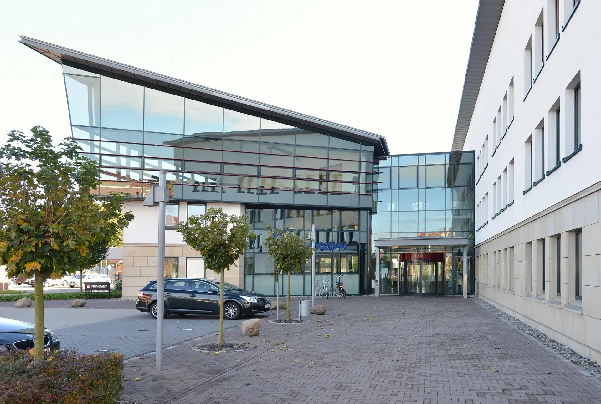 Ein schwarzes Auto steht vor einem großen Gebäude