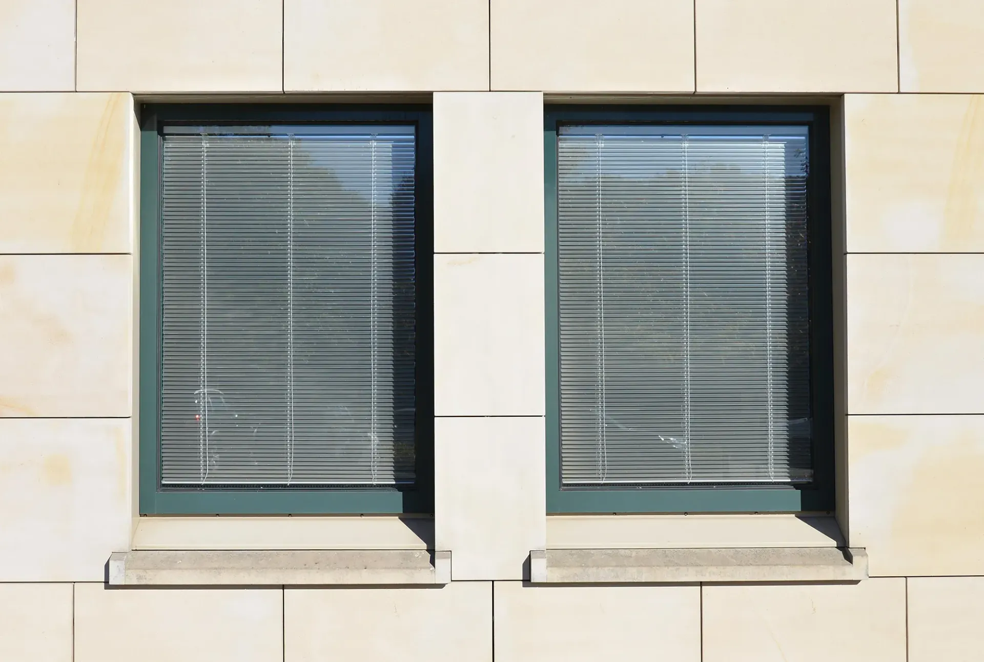 Zwei Fenster an einem Gebäude mit Jalousien