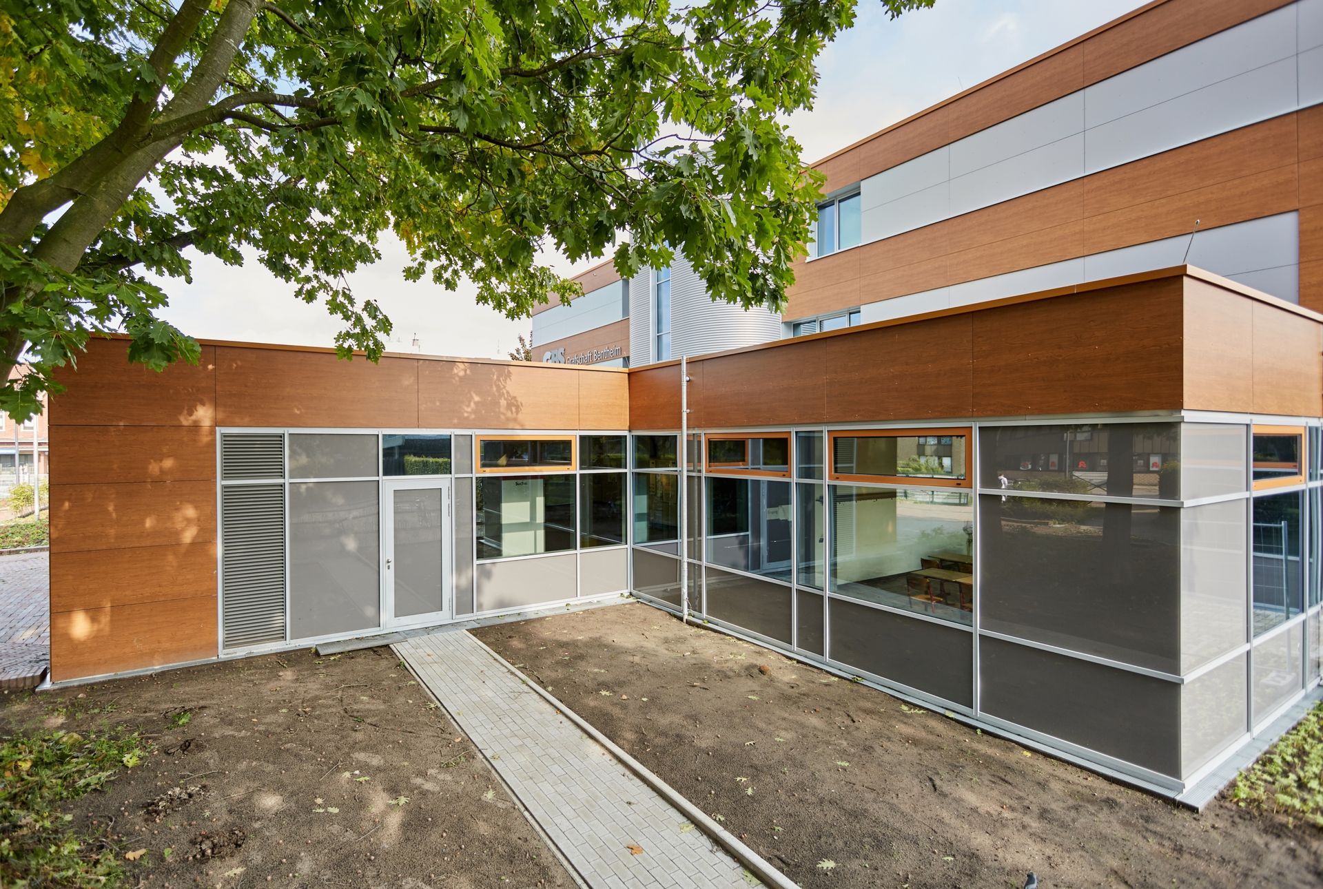 Ein Gebäude mit vielen Fenstern und einem Baum davor