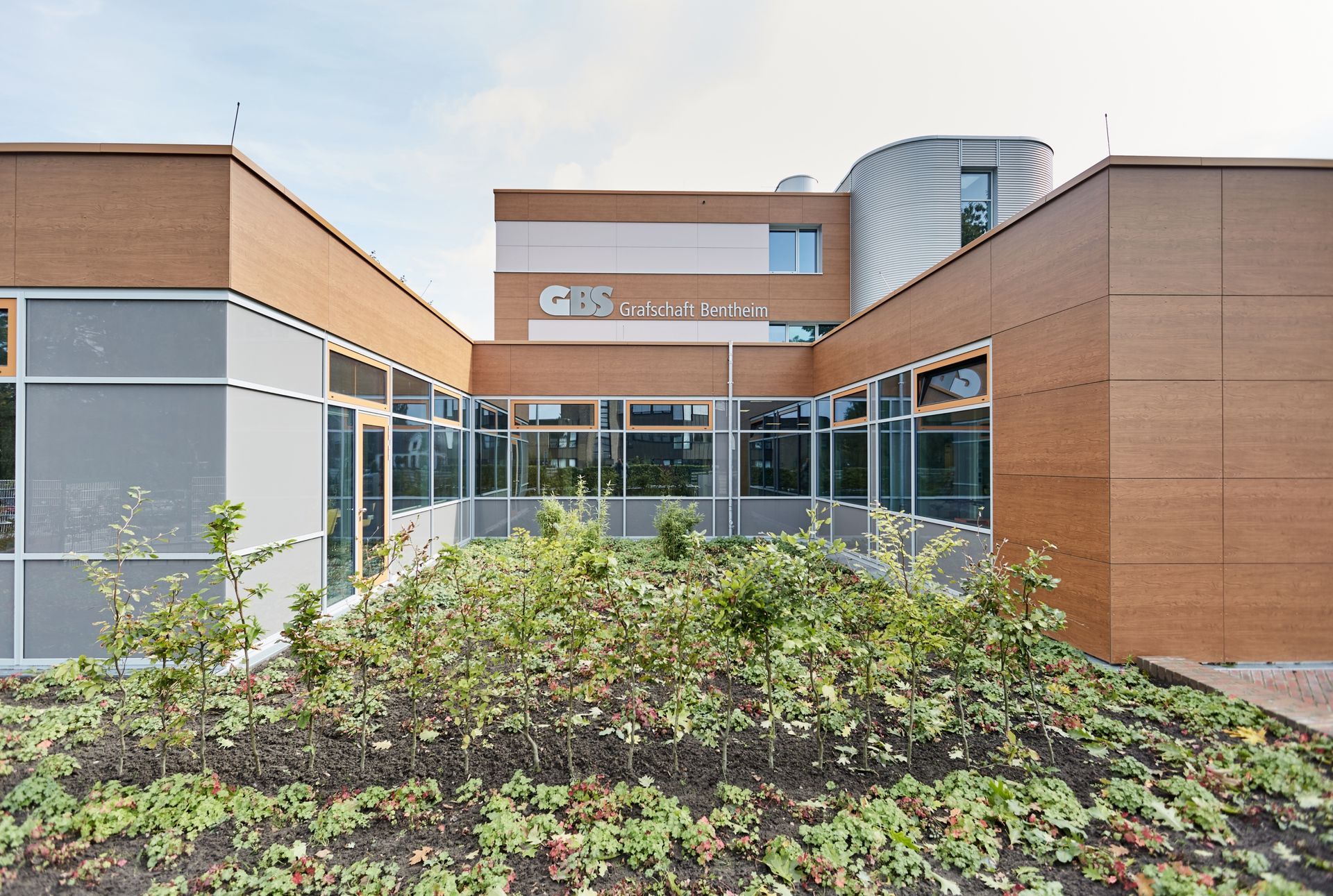 Ein großes Gebäude mit vielen Fenstern und Bäumen davor