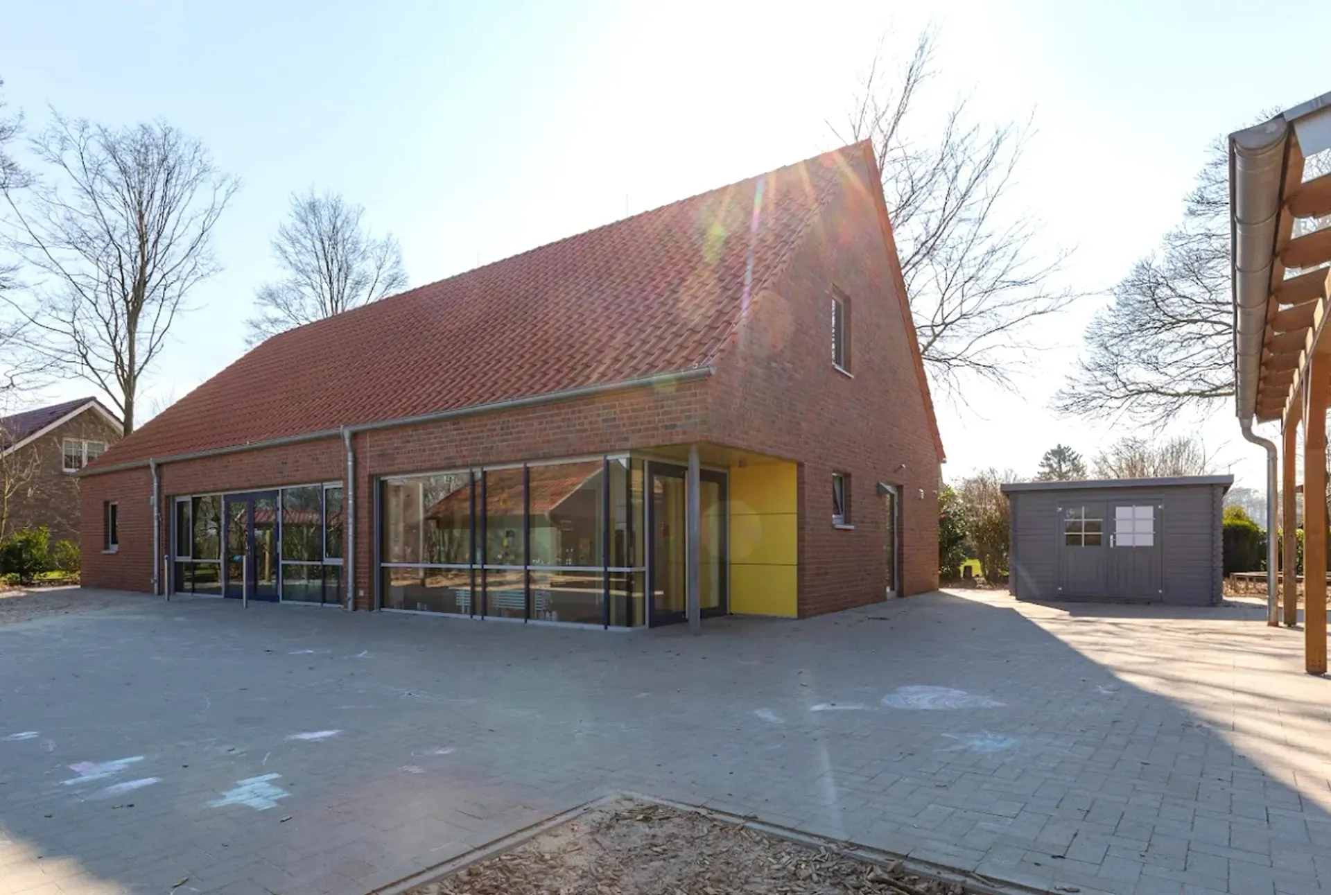 Ein großes Backsteingebäude mit einer gelben Tür und vielen Fenstern.