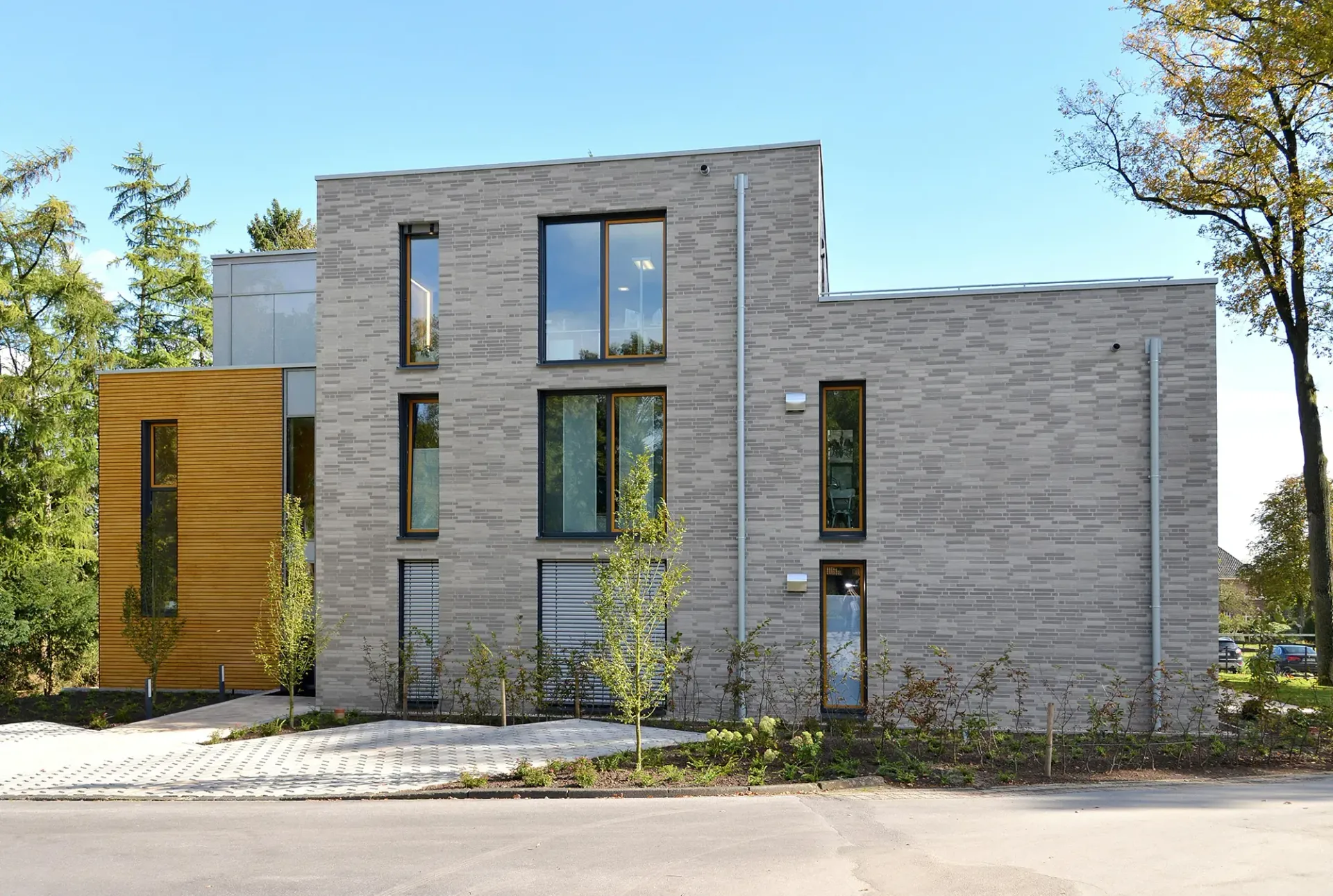 Ein großes Backsteingebäude mit vielen Fenstern und Bäumen im Hintergrund