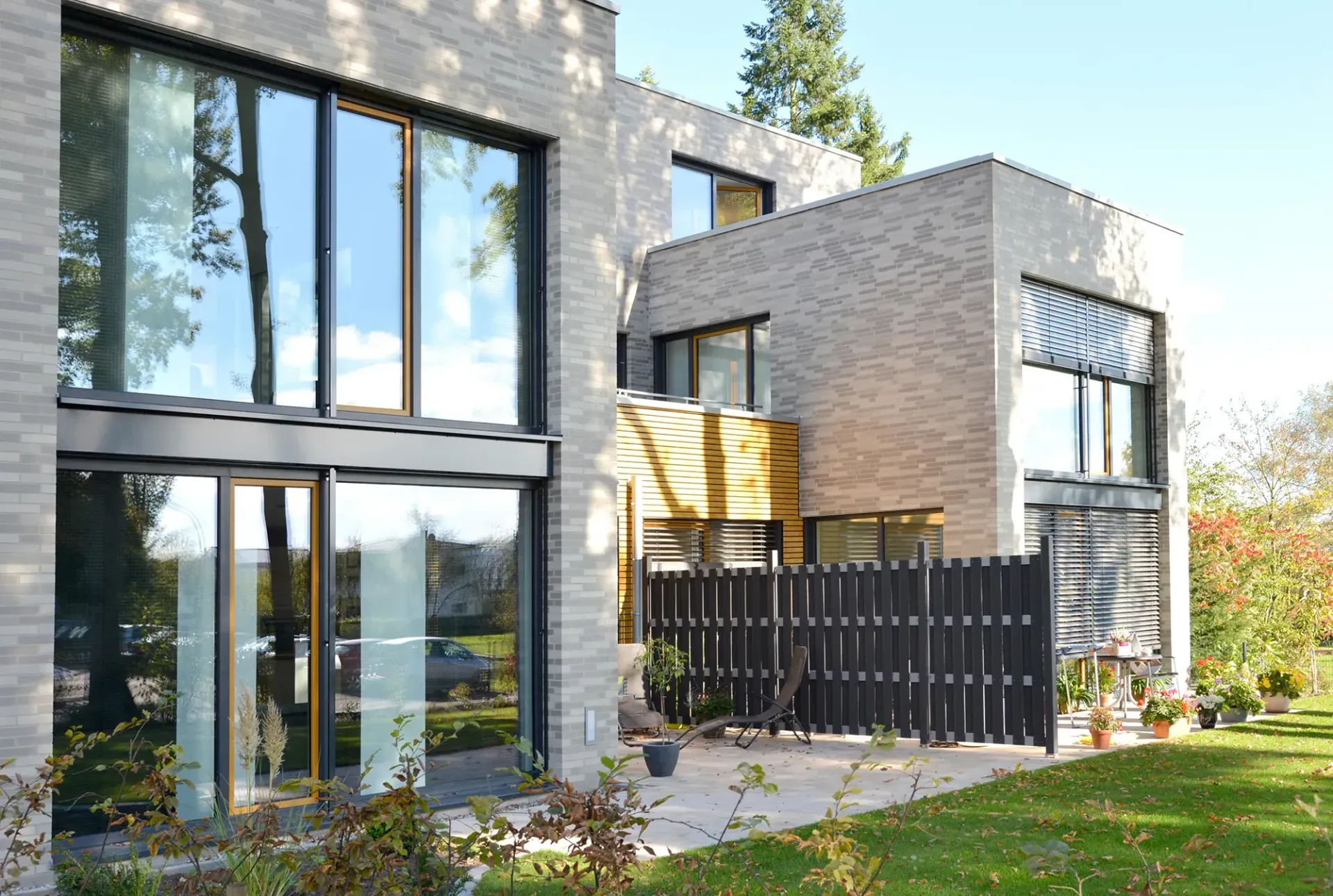 Ein Haus mit vielen Fenstern und einem Zaun davor.