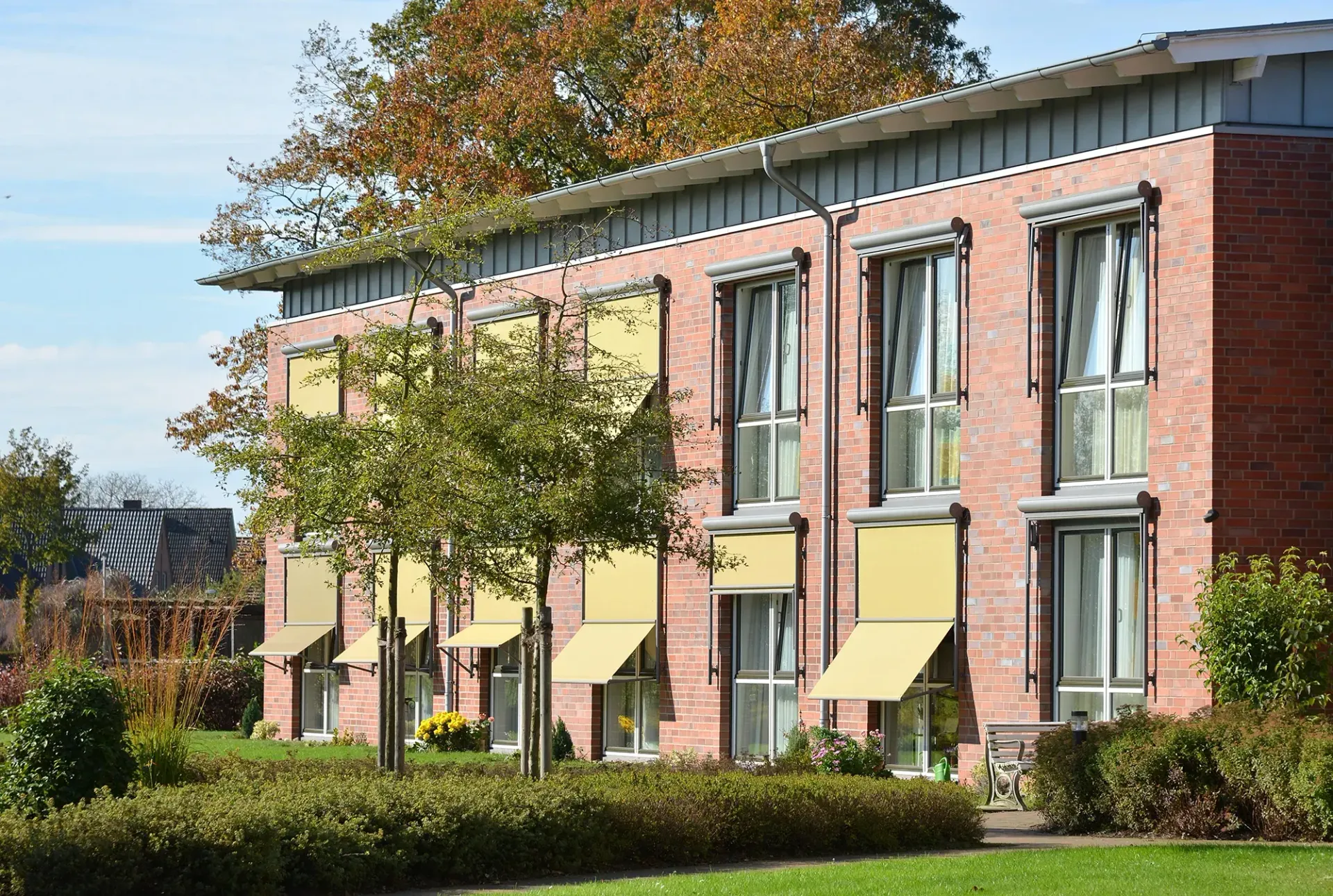 Ein Backsteingebäude mit gelben Markisen an den Fenstern