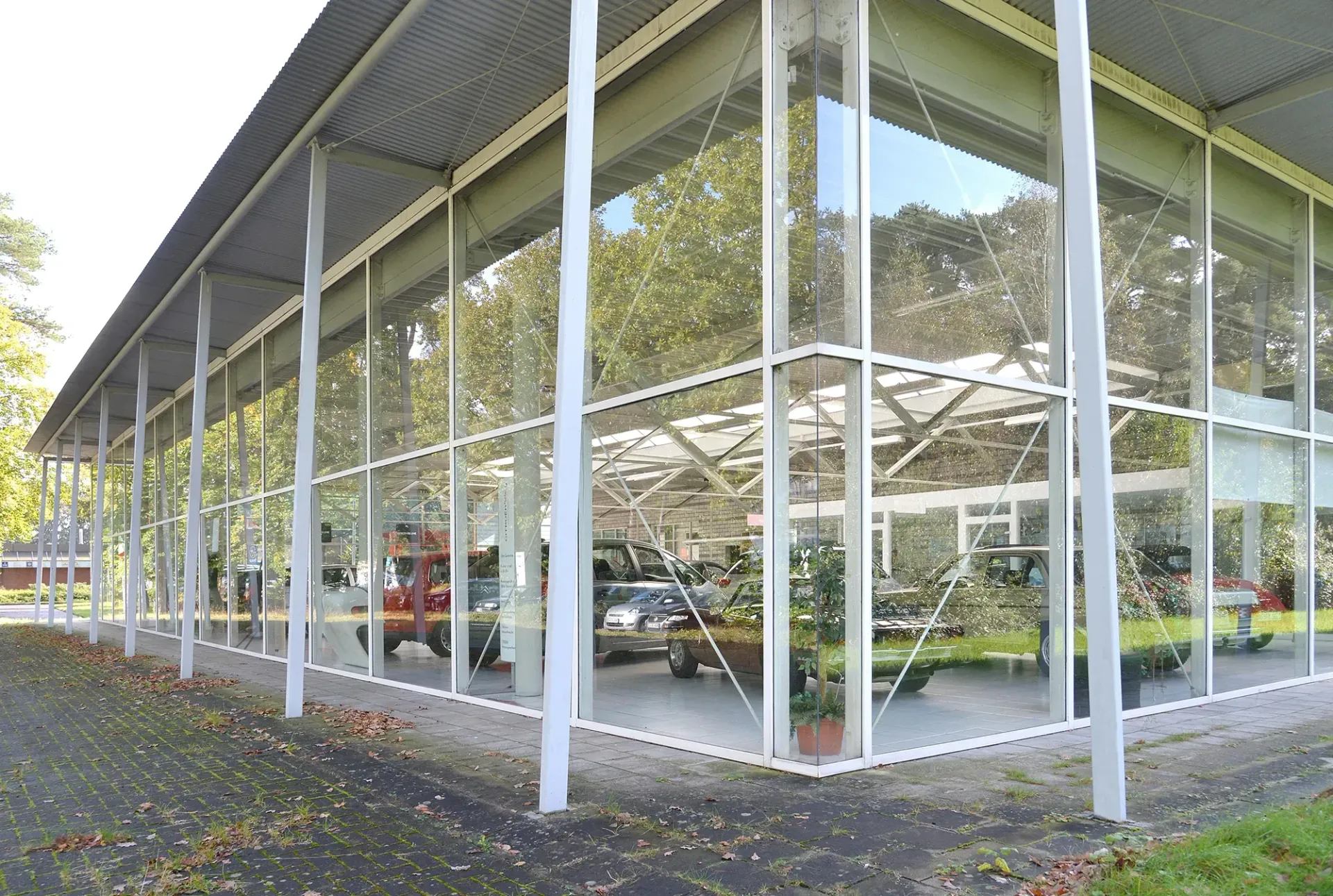 Ein großes Glasgebäude mit darin geparkten Autos