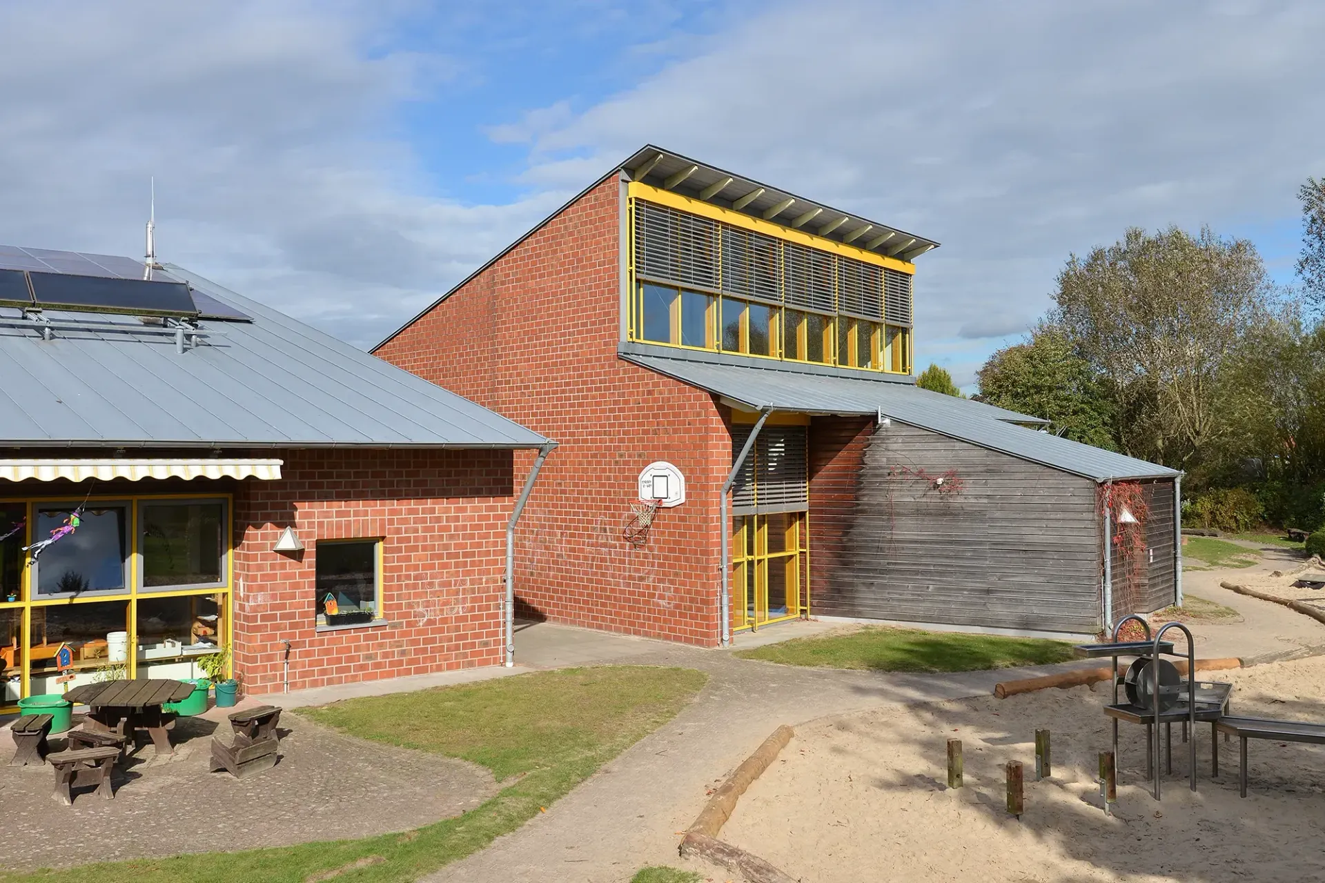 Ein Backsteingebäude mit einem Spielplatz davor
