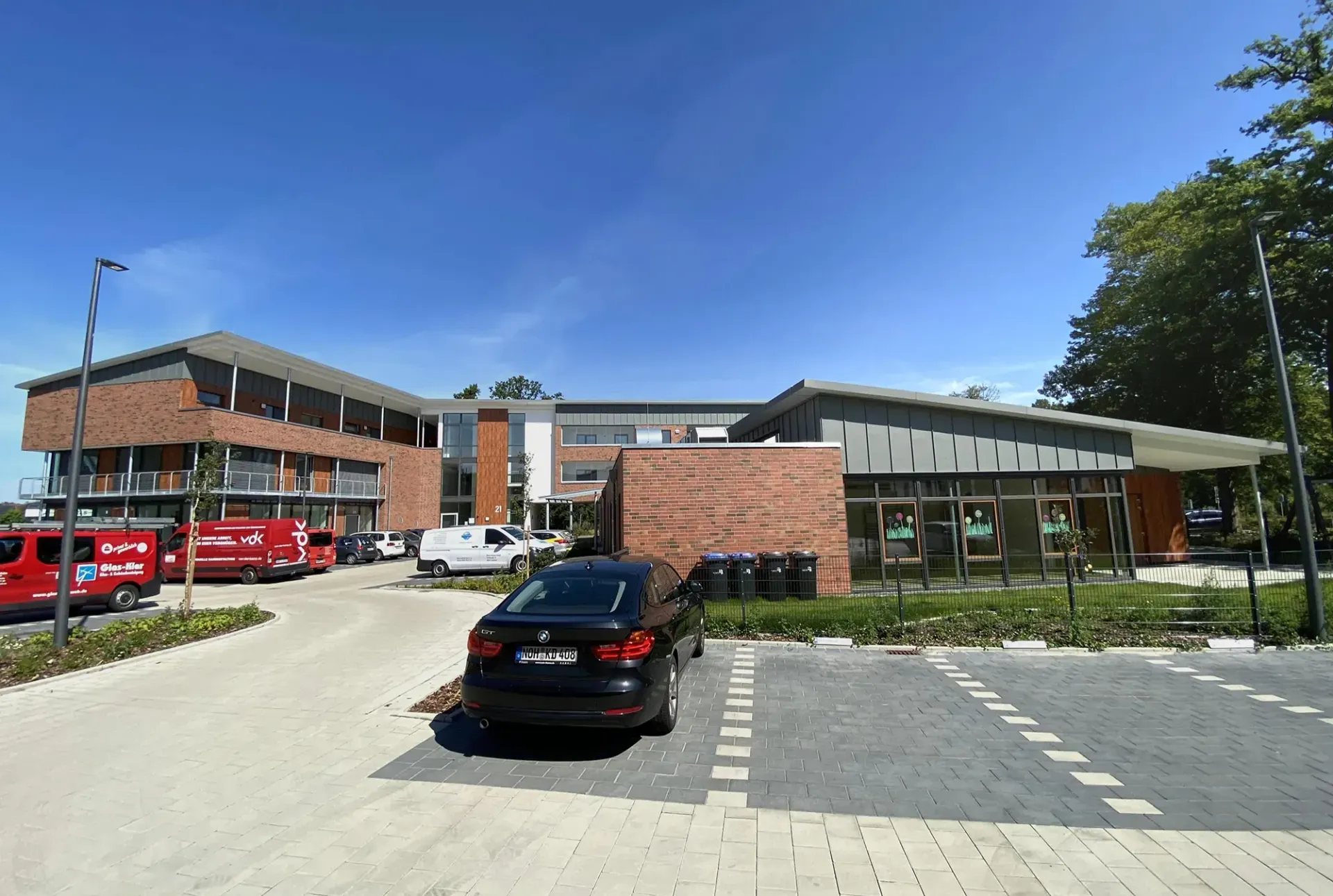 Vor einem großen Gebäude ist ein Auto geparkt.