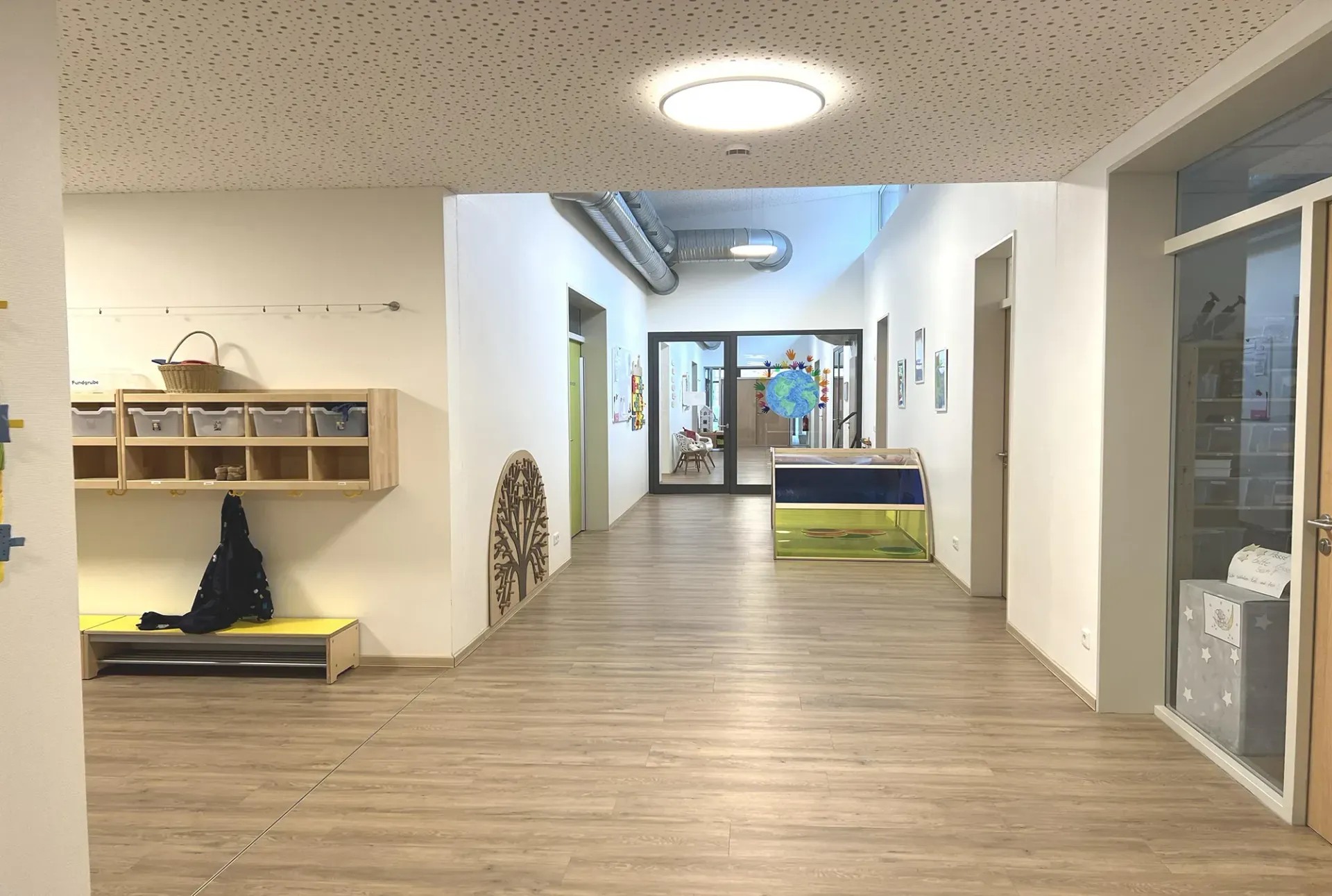 Ein Flur in einem Gebäude mit Holzböden und weißen Wänden.