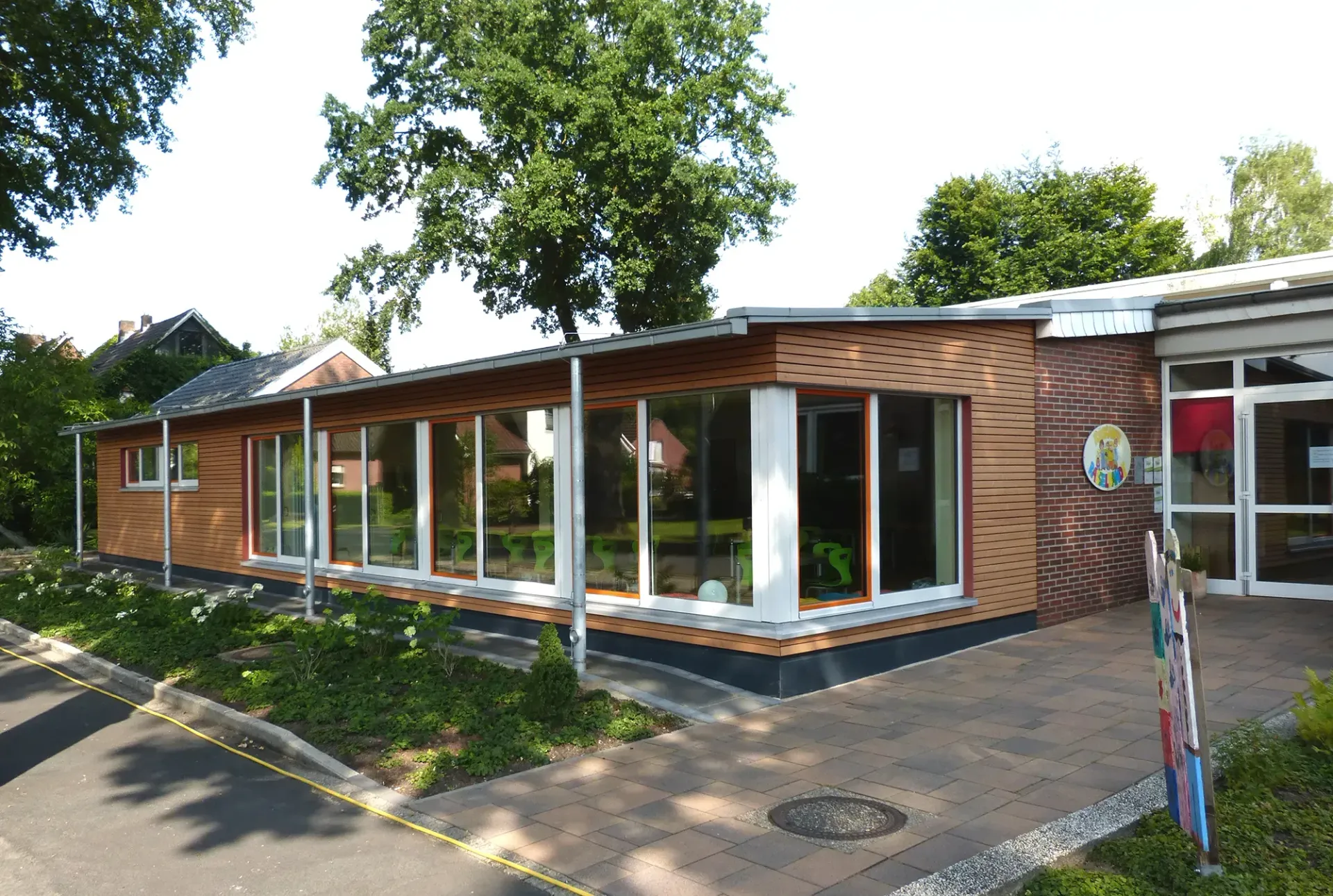 Ein Backsteingebäude mit vielen Fenstern und Bäumen im Hintergrund