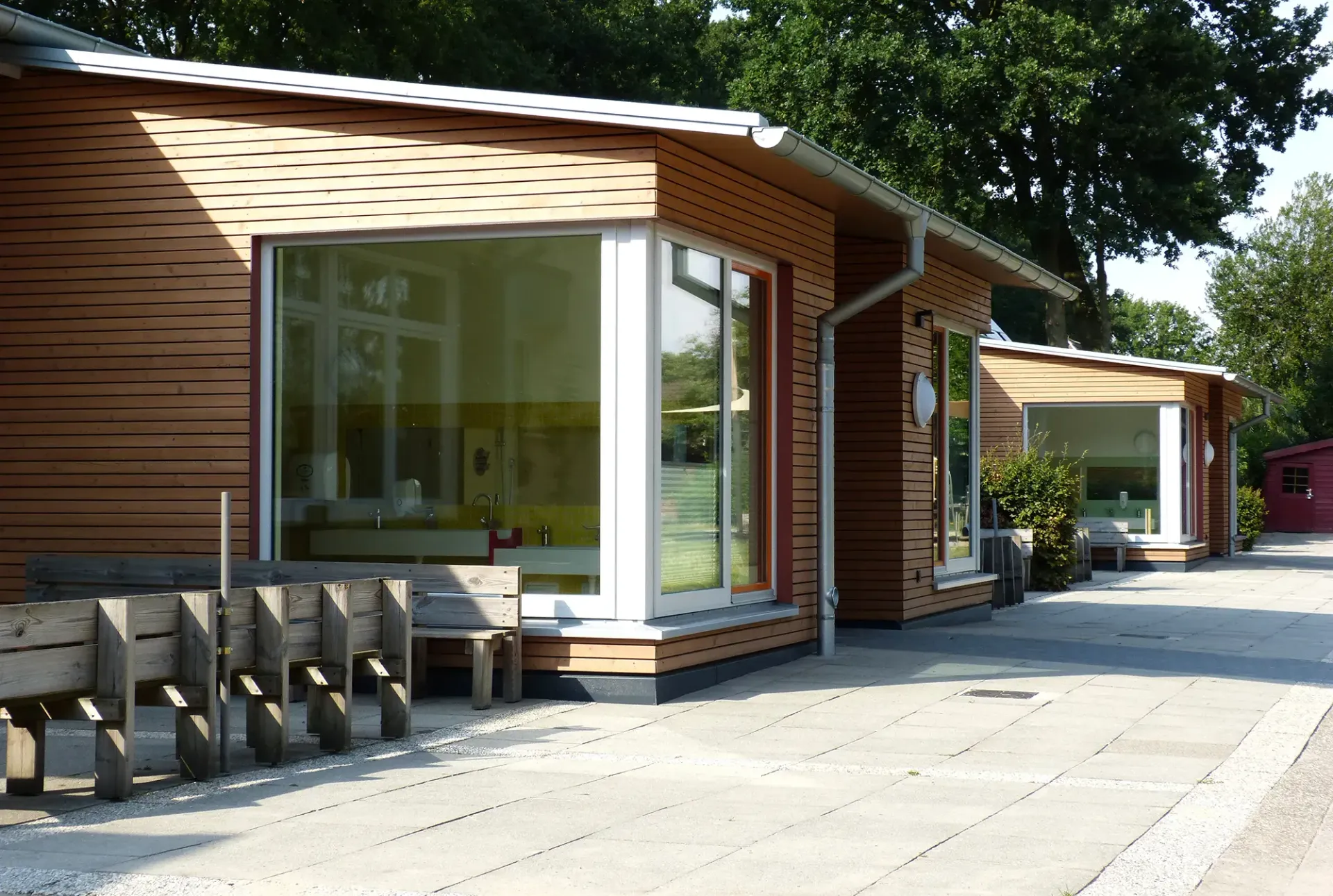 Eine Reihe von Holzhäusern mit Glasschiebetüren