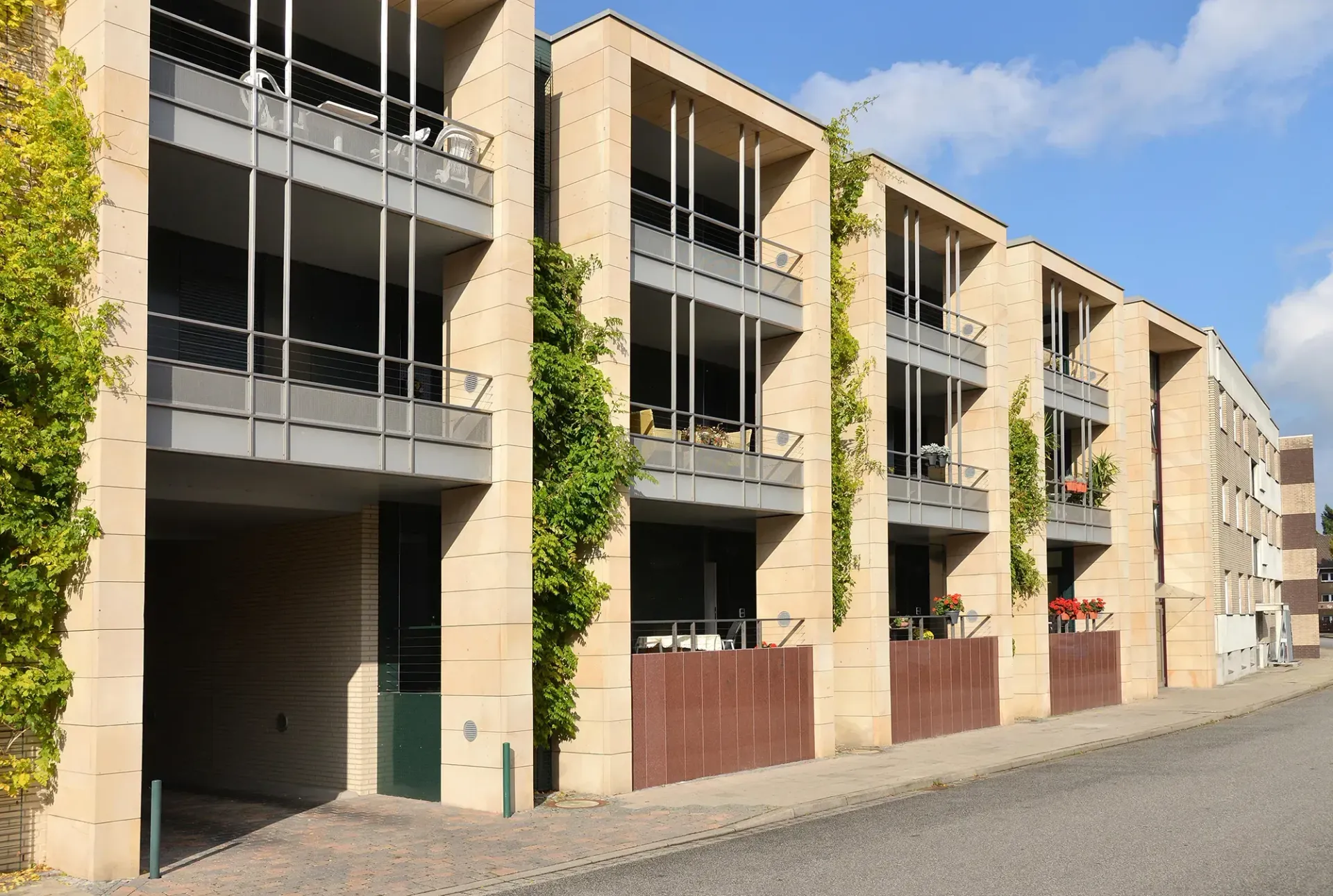 Eine Reihe von Mehrfamilienhäusern mit Balkonen an einem sonnigen Tag