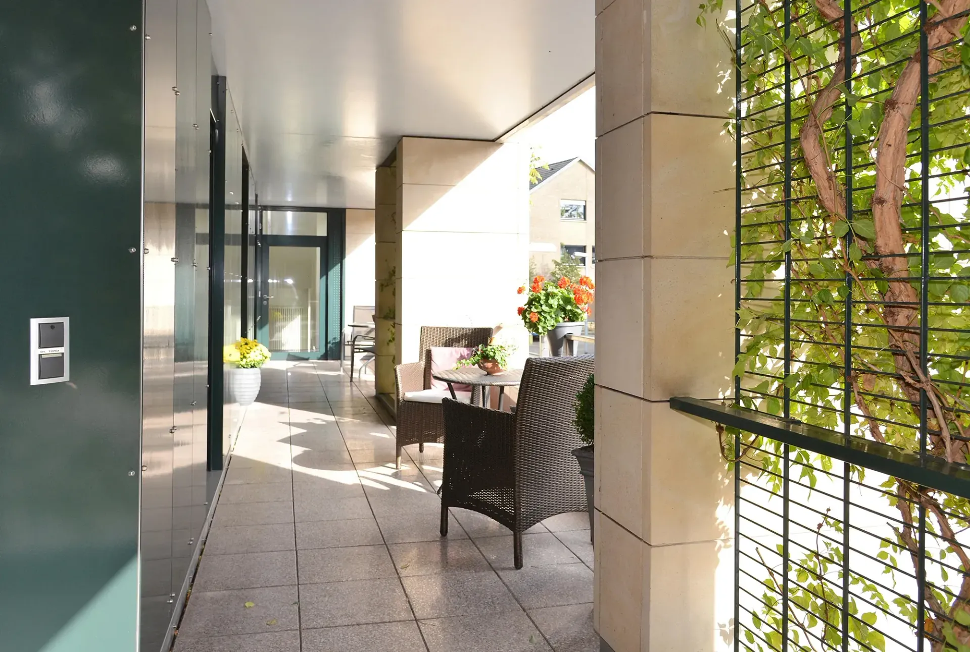 Ein Flur, der zu einem Balkon mit Stühlen und einem Tisch führt