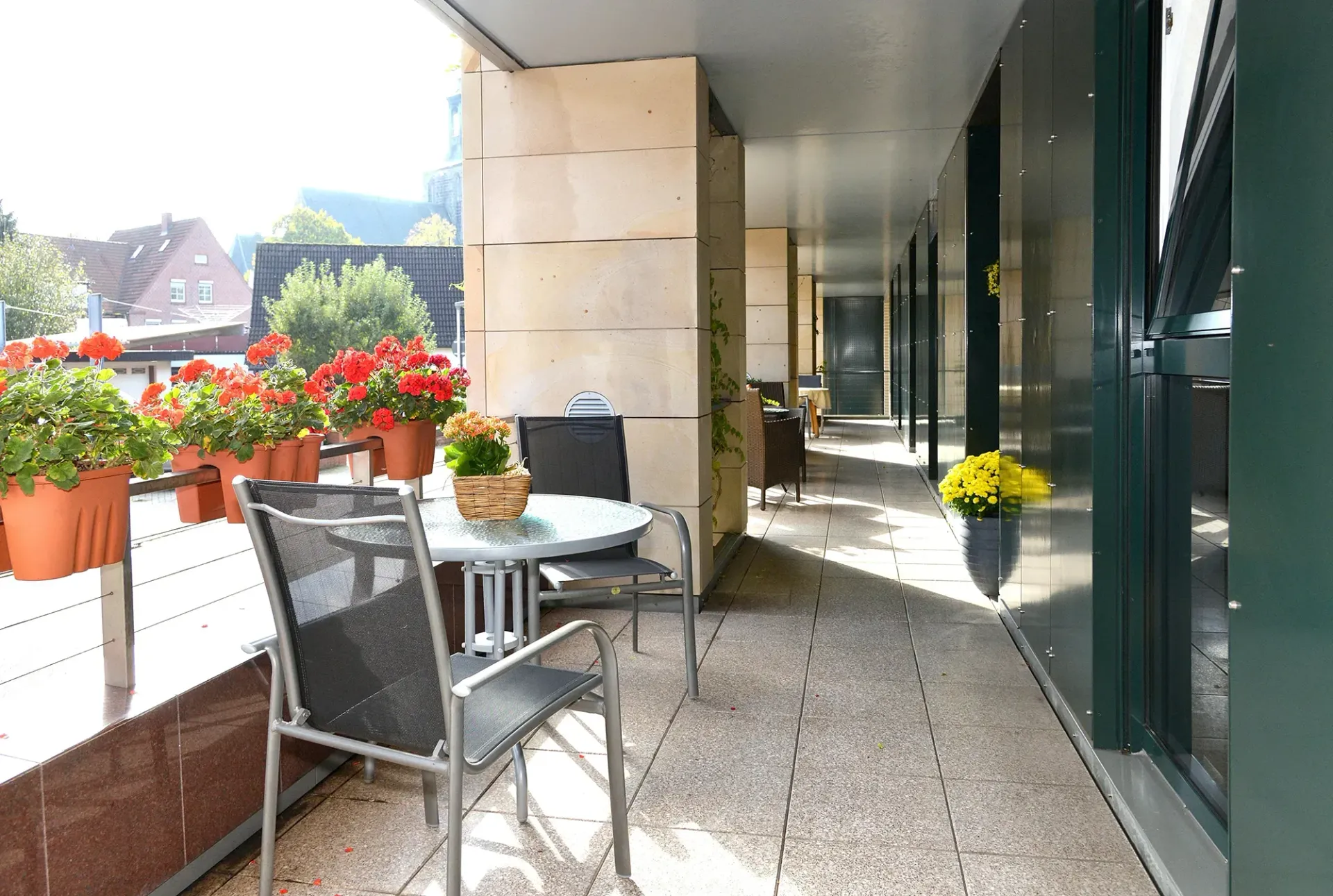 Ein Balkon mit Tisch und Stühlen und Topfblumen