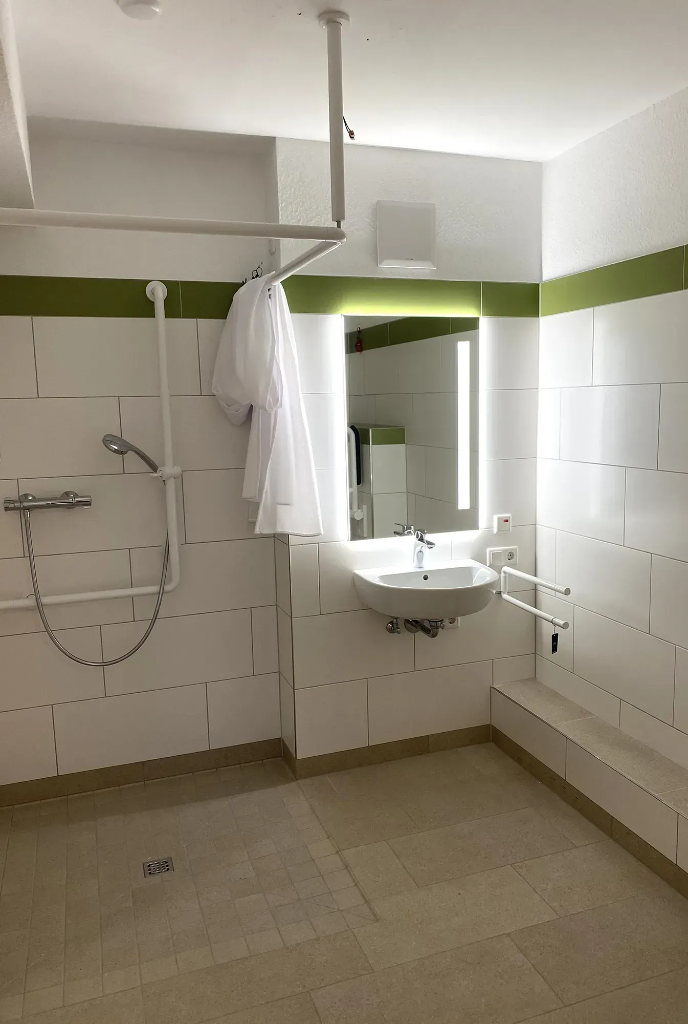 Ein Badezimmer mit Waschbecken, Dusche und Spiegel.